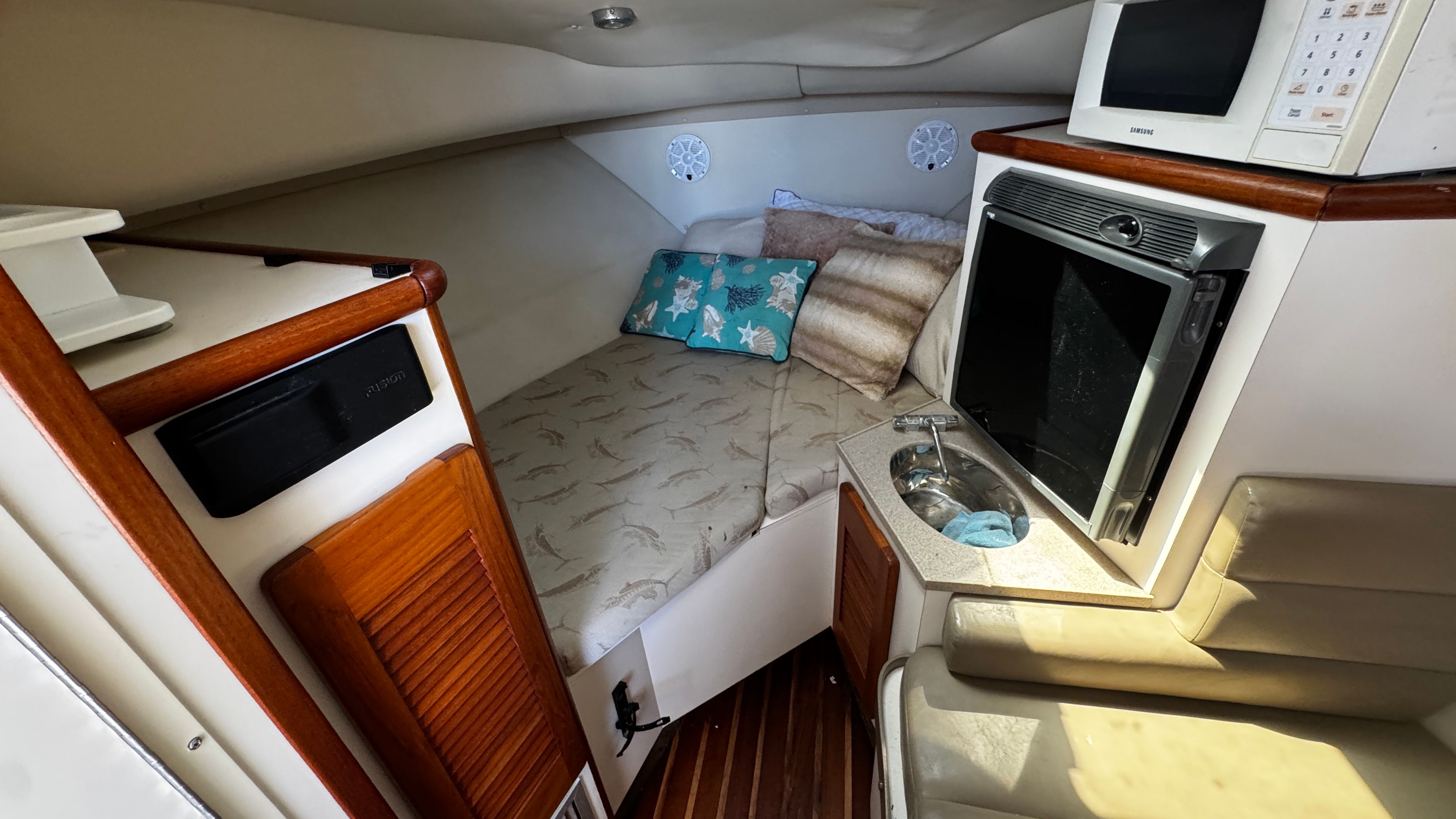 Interior of a 2003 Pursuit 3070 with a bed, microwave, and sink.