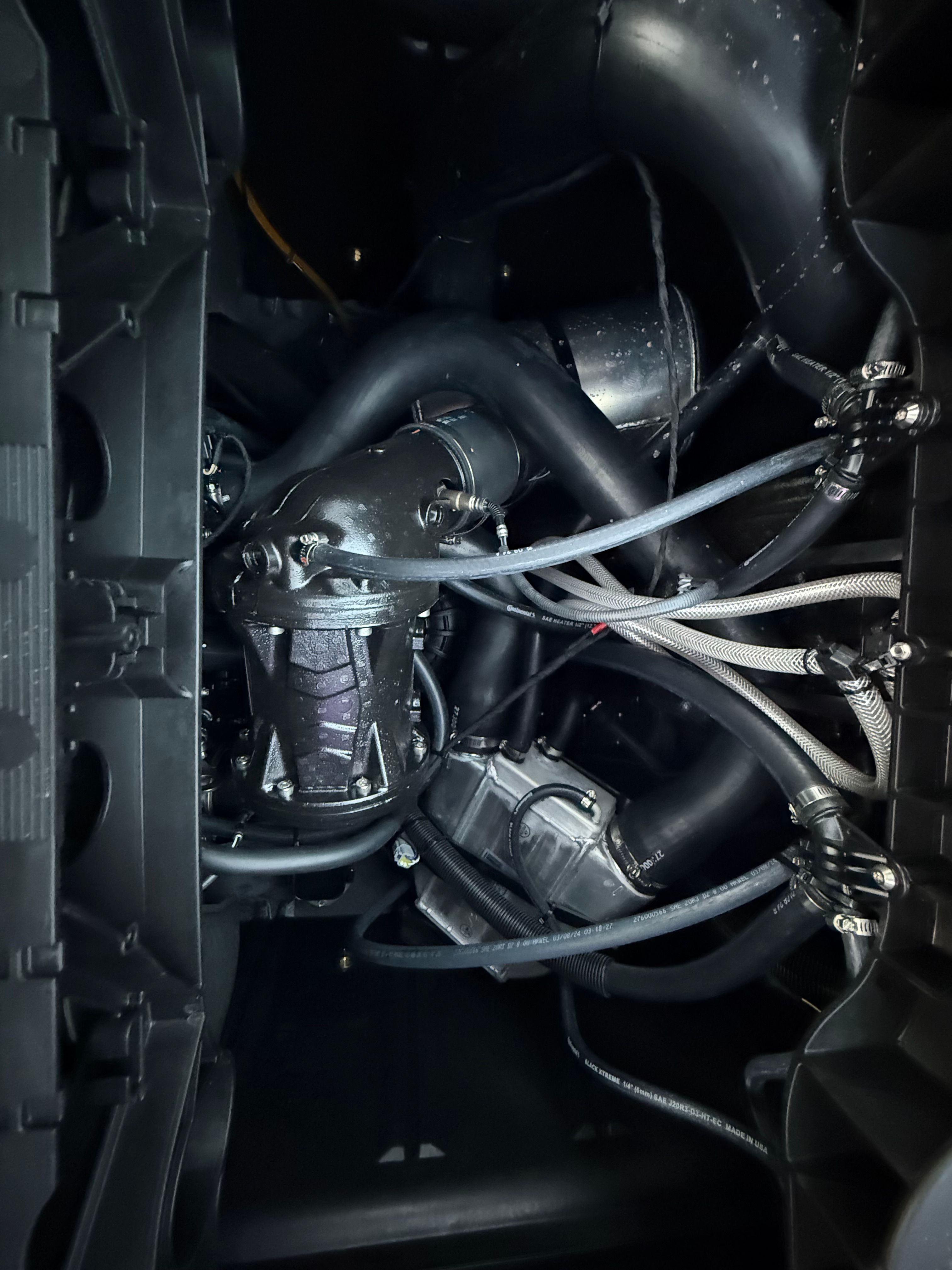 Engine compartment of a 2025 Sea-Doo Switch Cruise Limited 21 with complex hoses and cables.