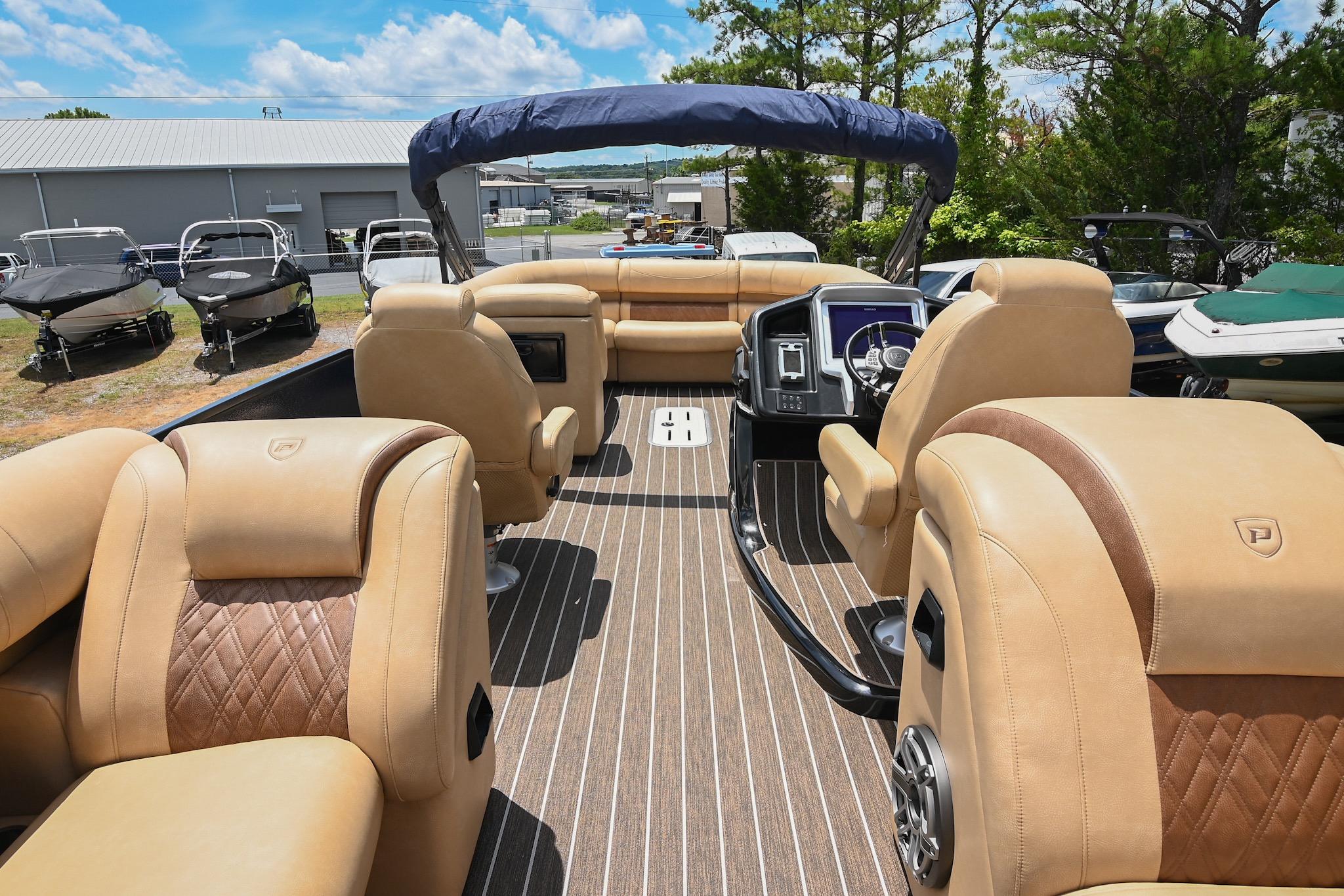 Luxurious interior of 2023 Premier 270 Intrigue RF pontoon boat with tan seating.