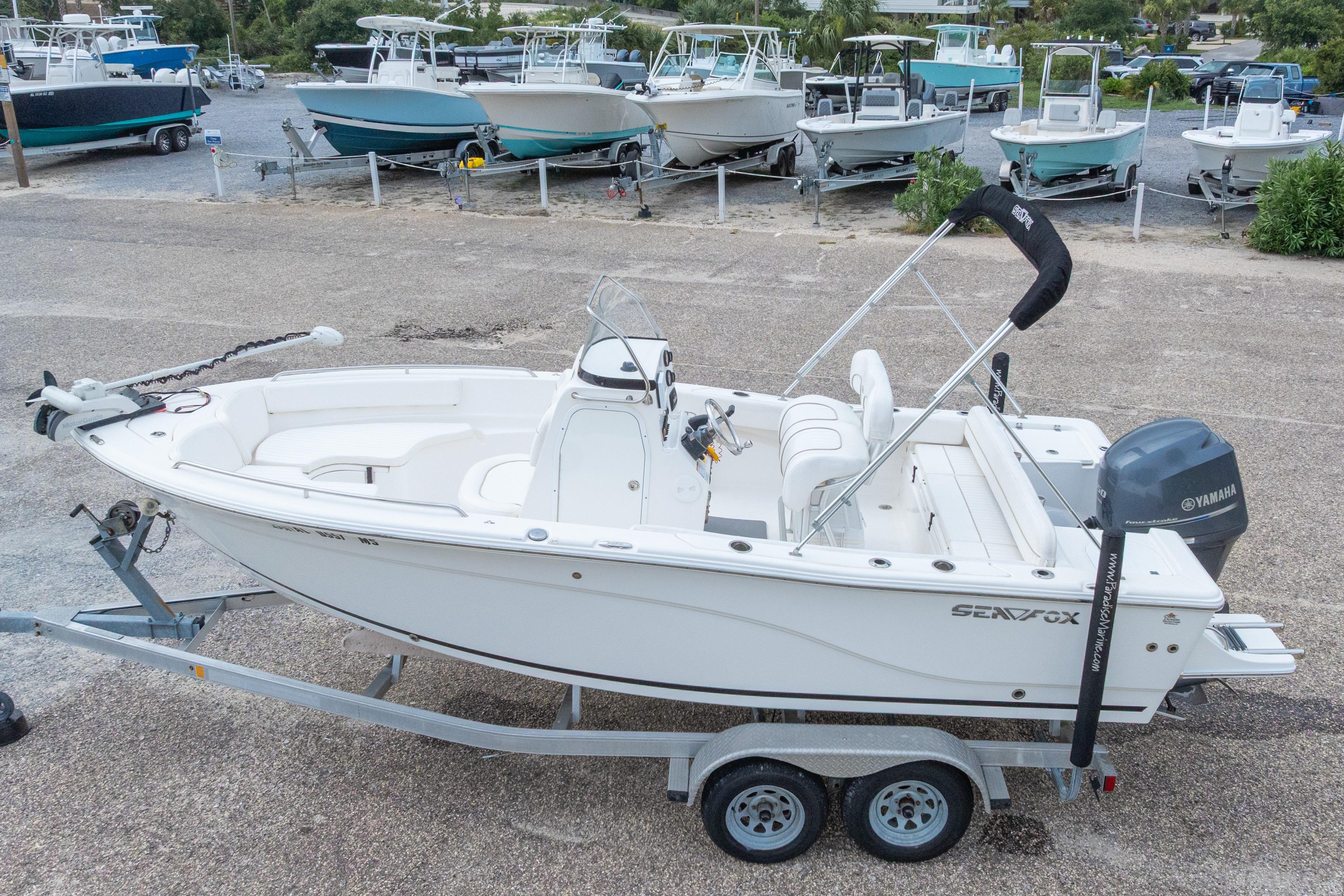 2014 Sea Fox 209 Commander boat on trailer, parked in a marina.