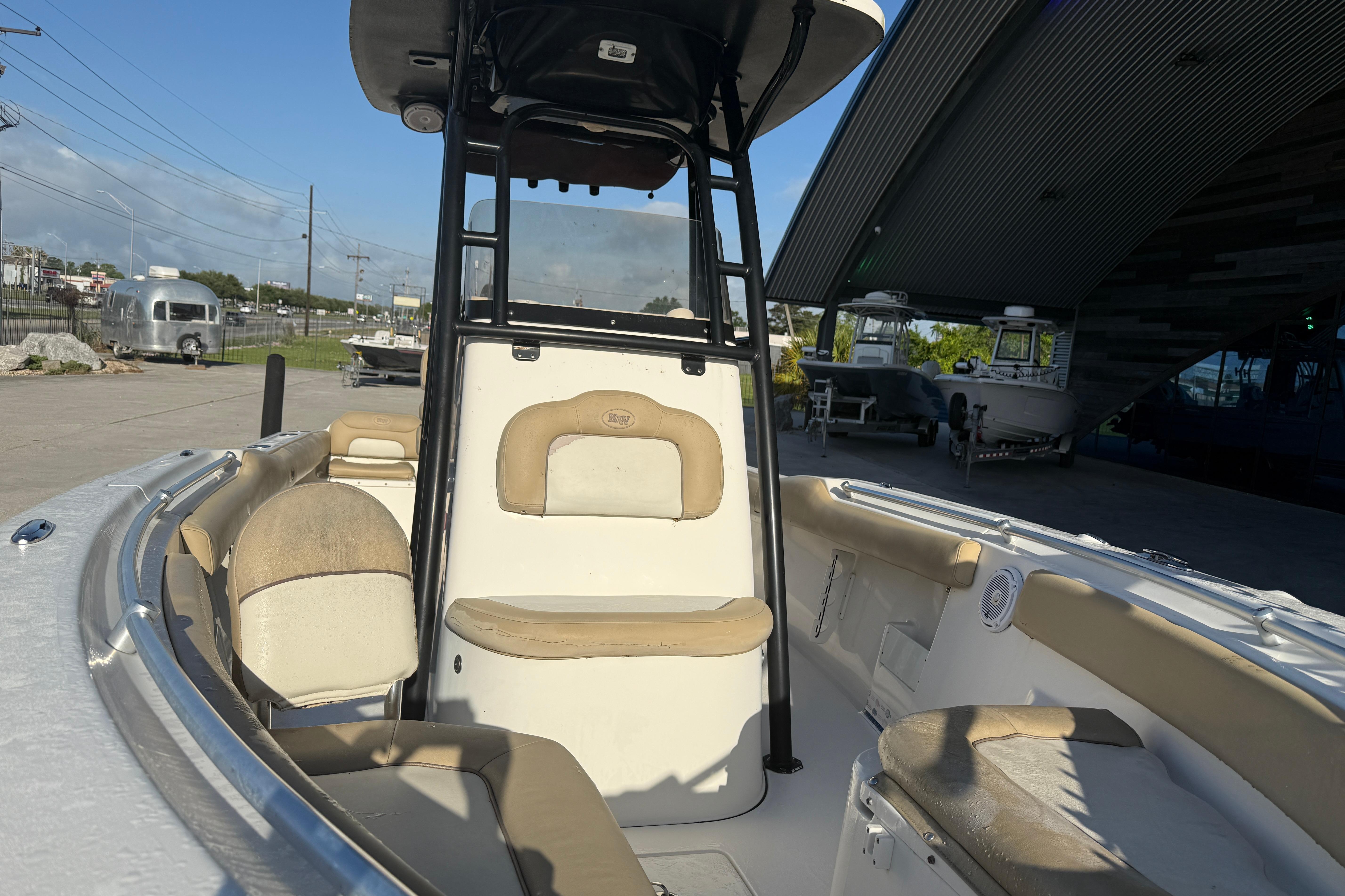 2016 Key West 239 FS boat interior with beige seating and T-top in a marina setting.