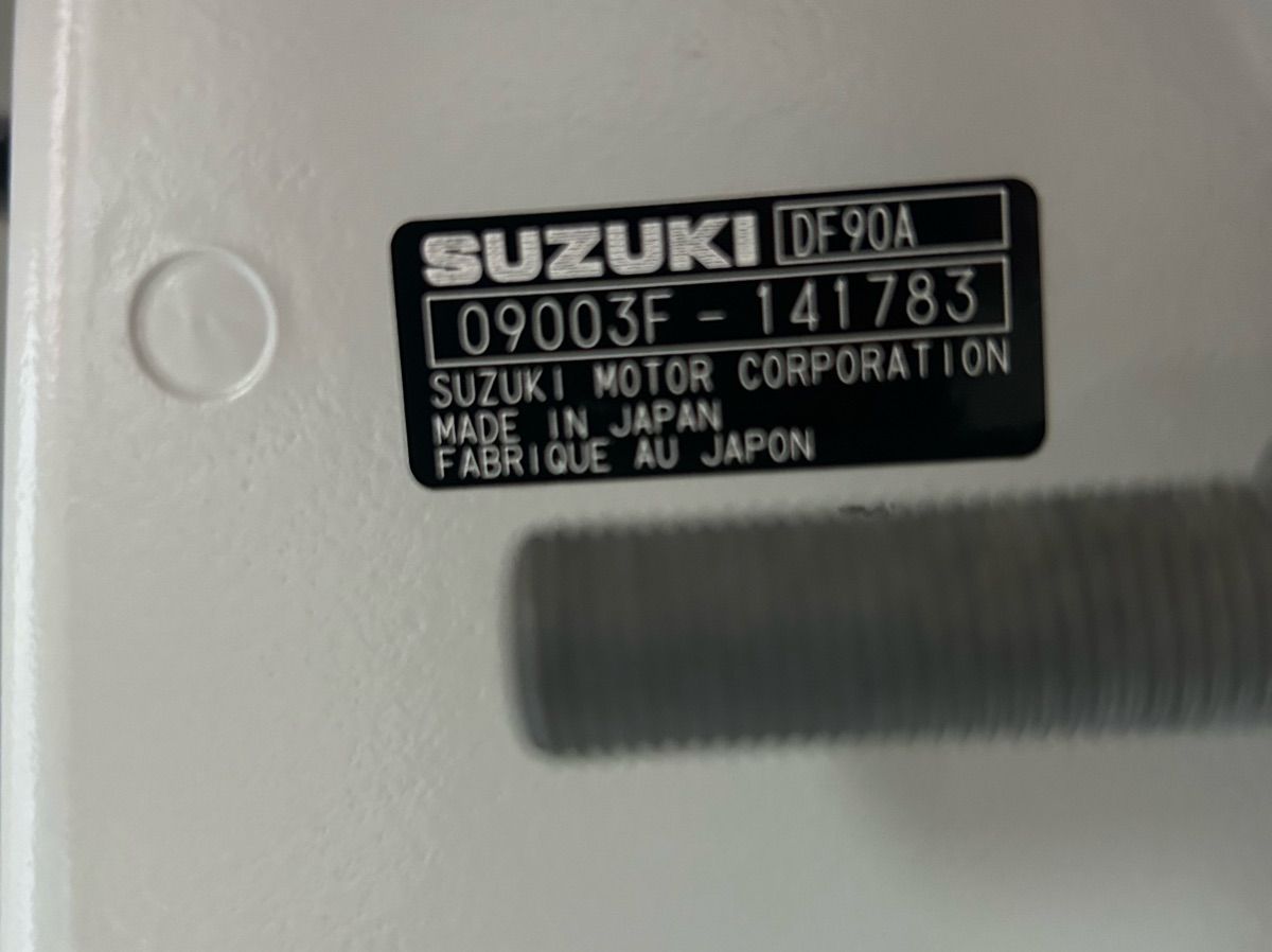 Close-up of a Suzuki engine part with serial number and country of origin.