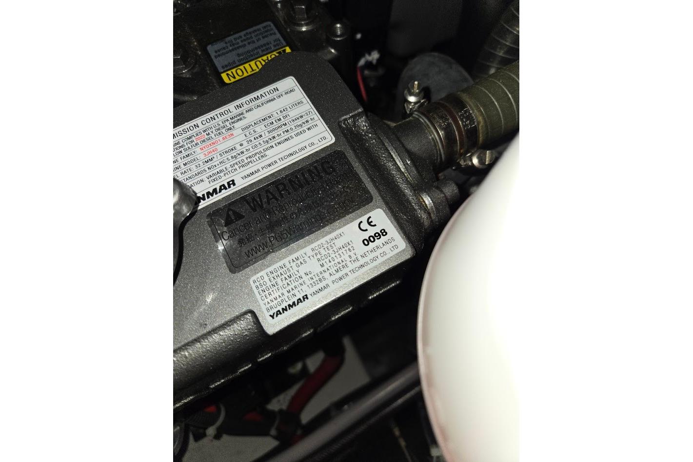 Engine compartment of 2023 Beneteau Oceanis 38.1, featuring Yanmar components and warning labels.