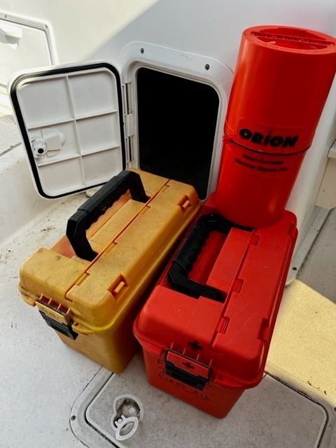 Two toolboxes and a red container on a boat.