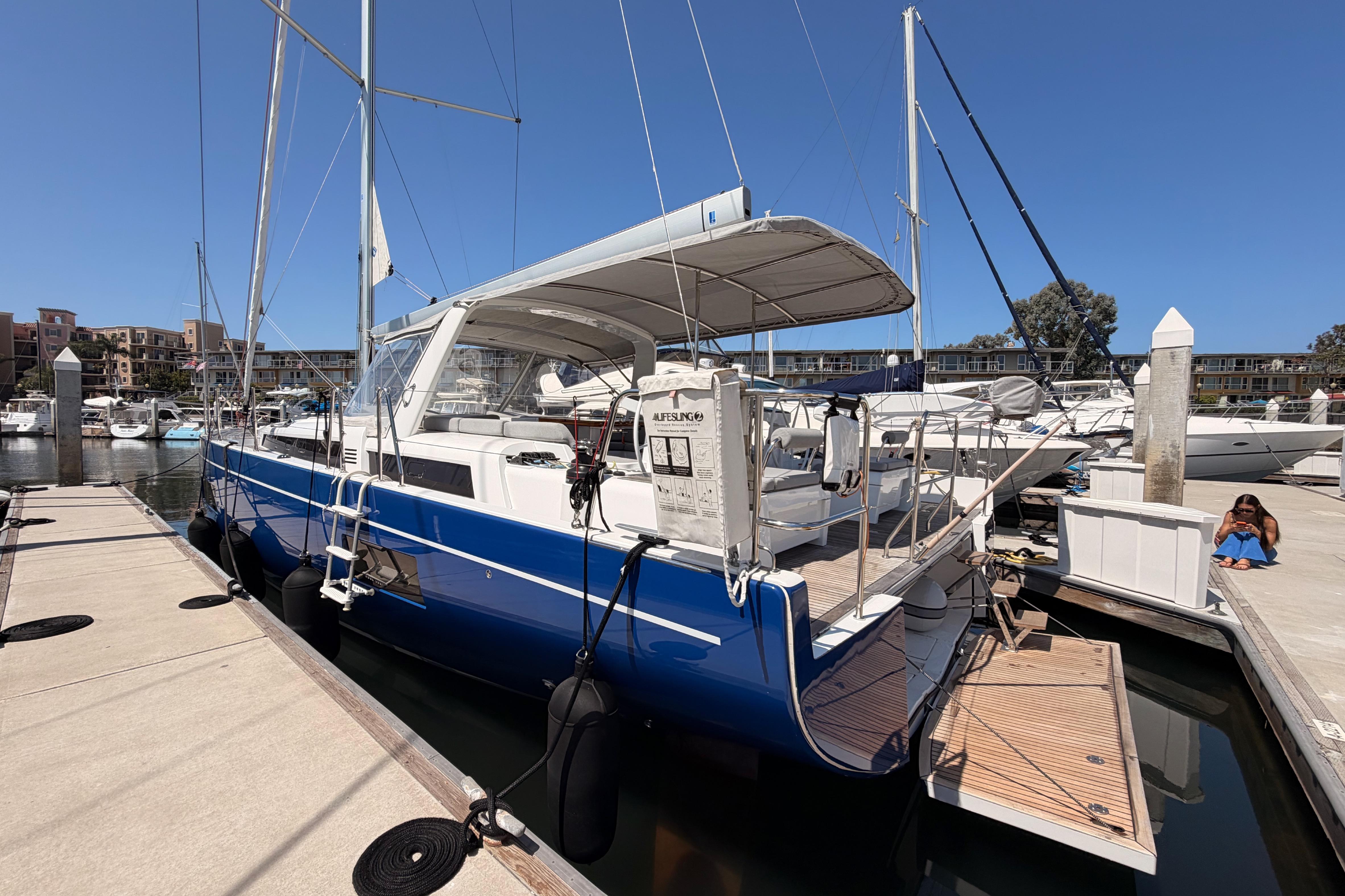 2022 Beneteau Oceanis Yacht 54 docked at marina, featuring sleek blue hull and spacious deck.