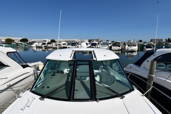 2010 Cruisers Yachts 390 Sports Coupe docked in a marina, surrounded by other boats.