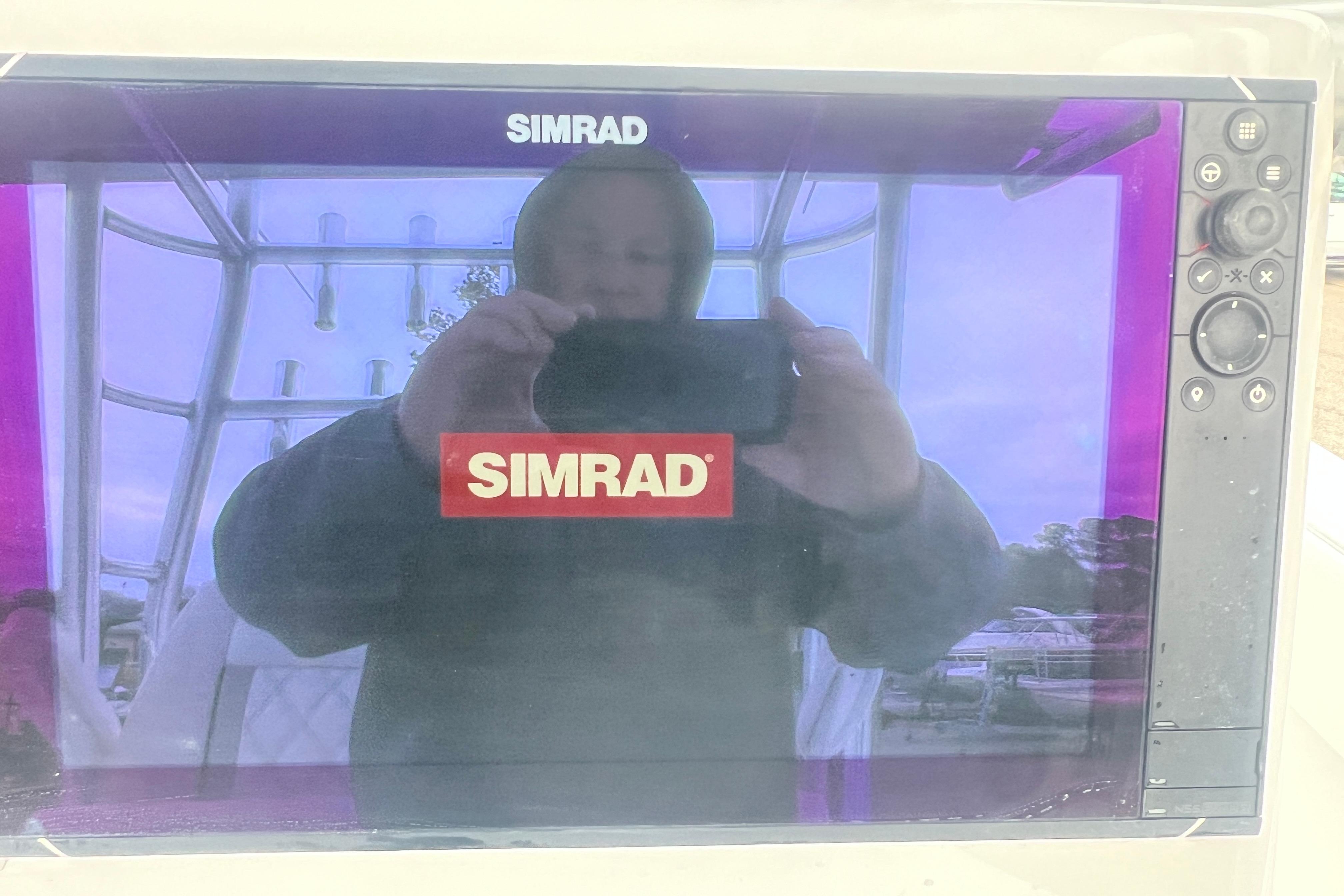 Simrad display on 2022 Sea-Lion 34 TE boat, reflecting a person taking a photo.