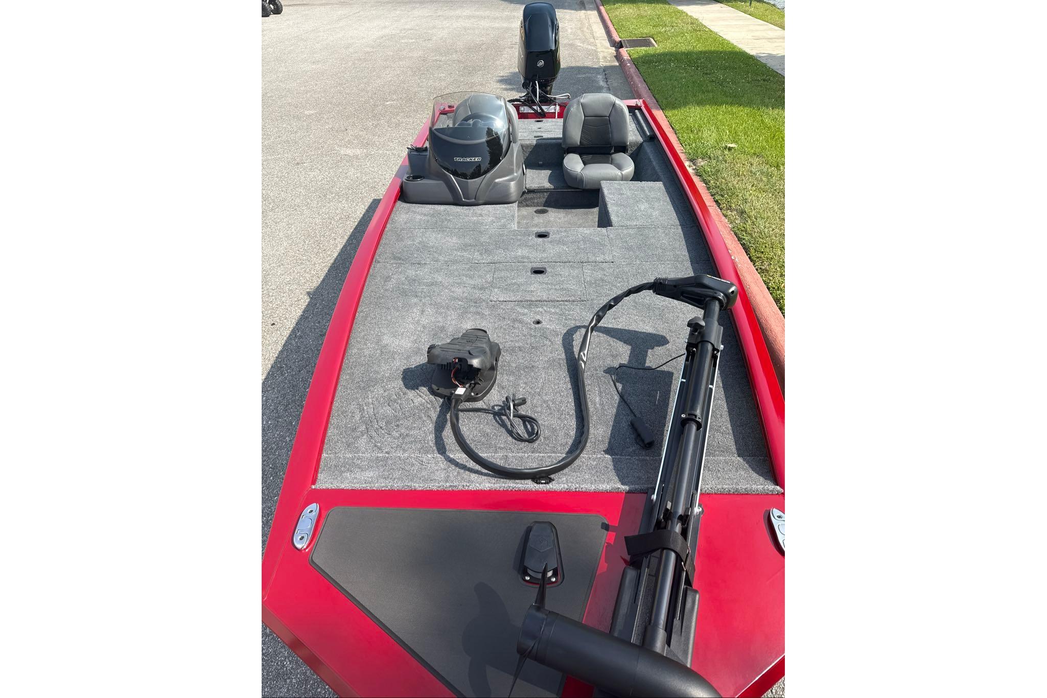 2026 Tracker Pro 170 boat with red exterior and gray interior, parked on pavement.