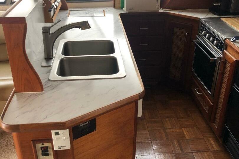 1985 Bayliner 4550 Motoryacht kitchen with dual sinks and wooden cabinetry.