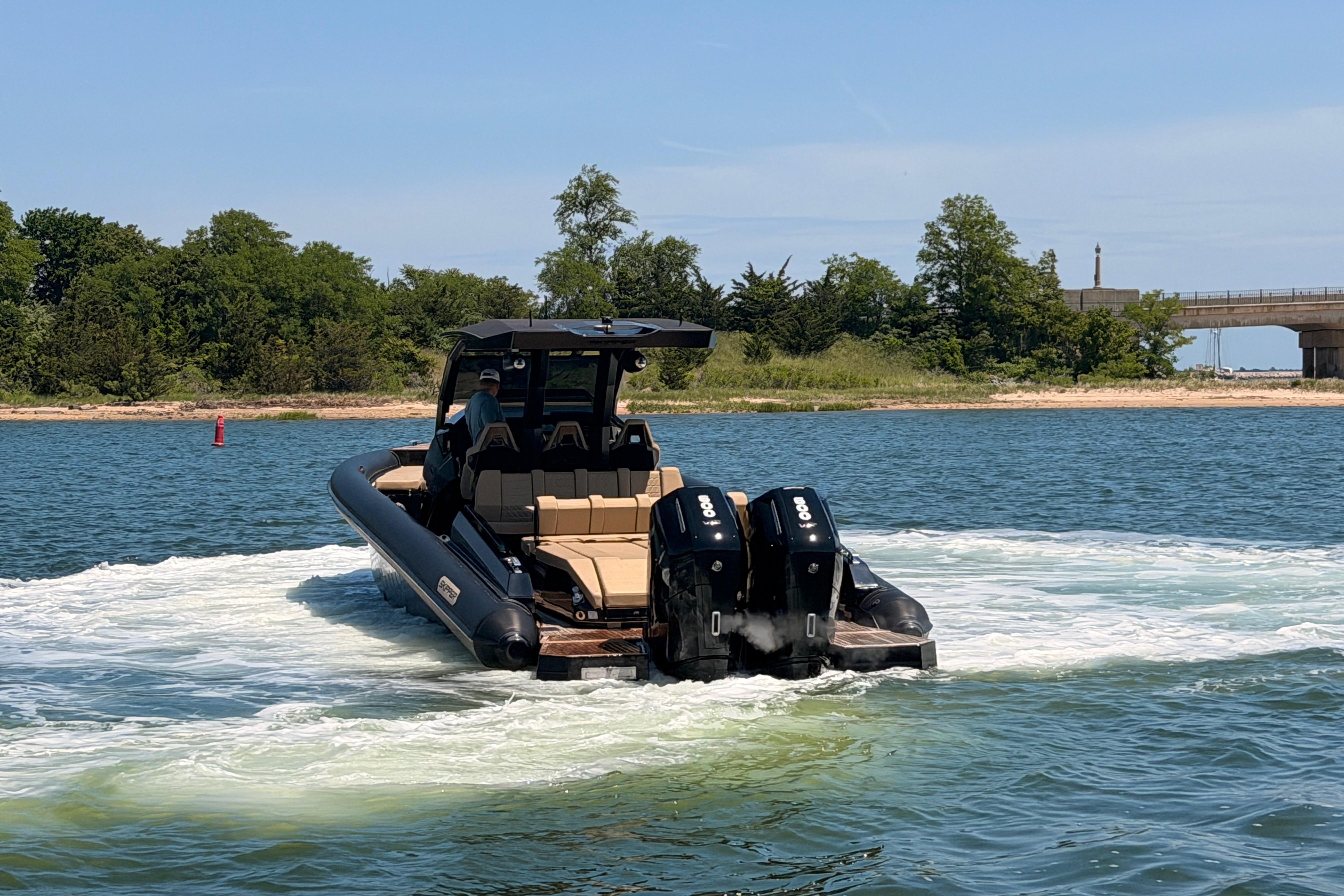 2023 Skipper-BSK 42NC boat cruising on a scenic waterway with lush greenery.