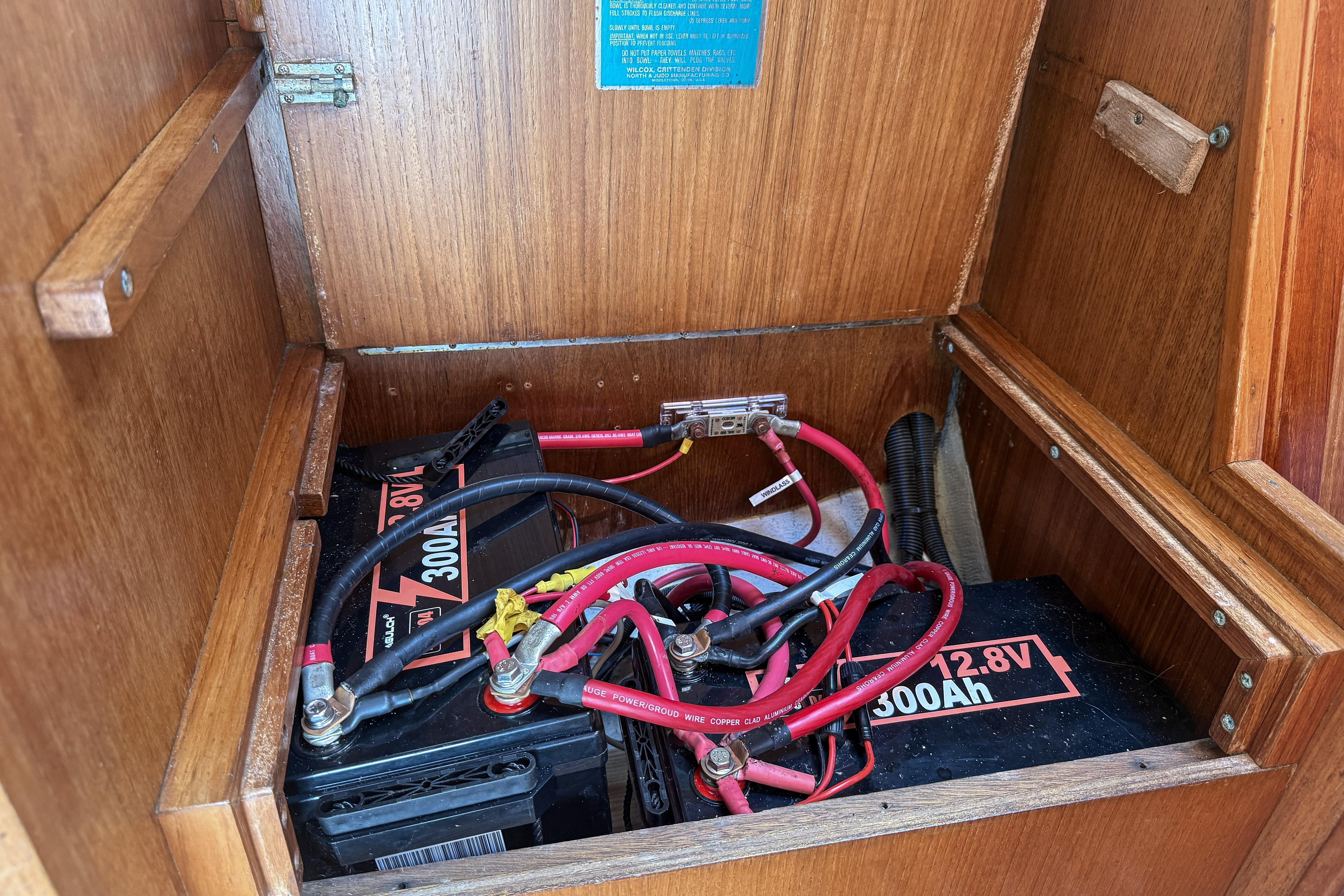 Battery compartment of a 1988 Oday 40 sailboat with wiring and connections.