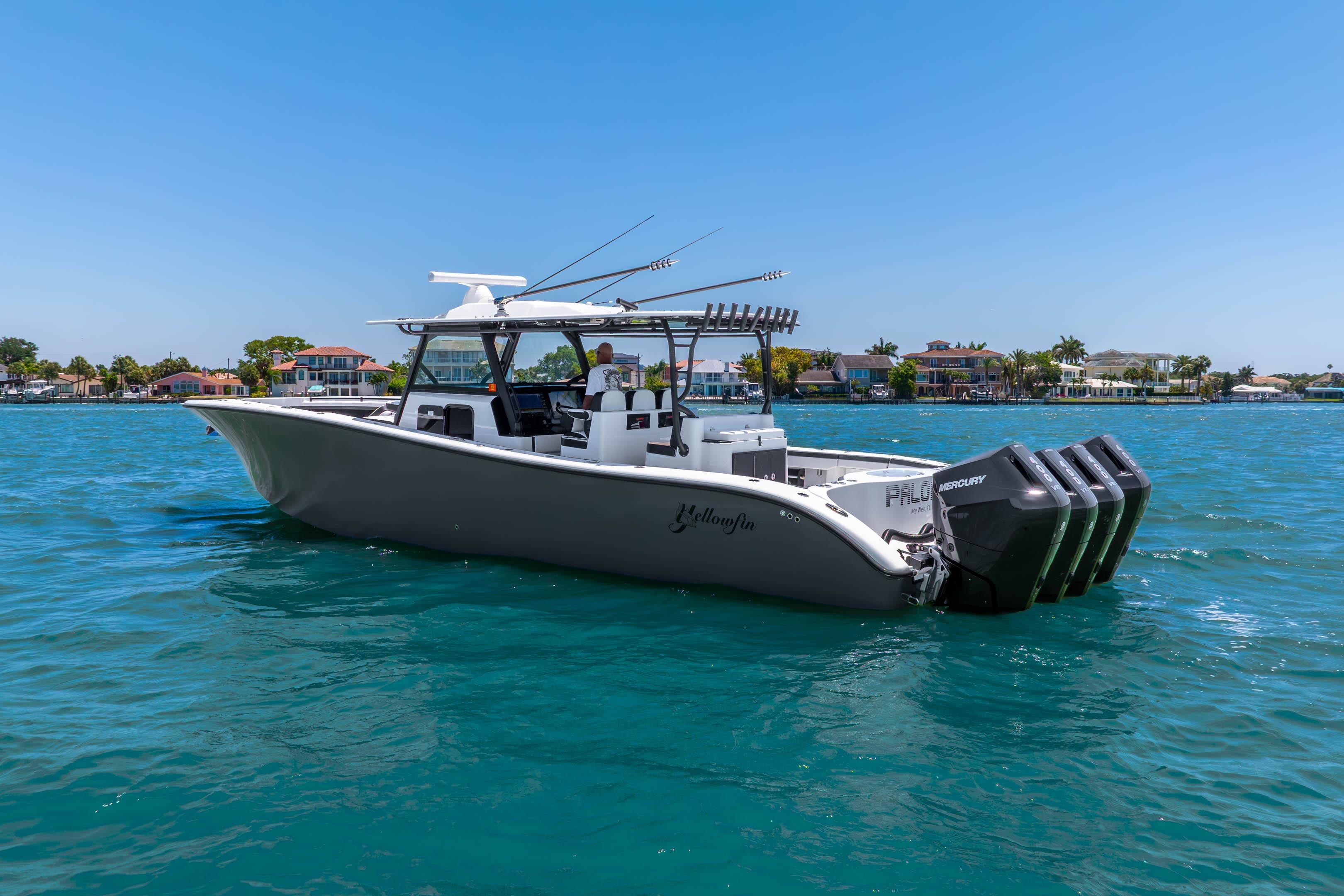 2024 Yellowfin 42 Offshore boat cruising on clear blue water near coastal homes.