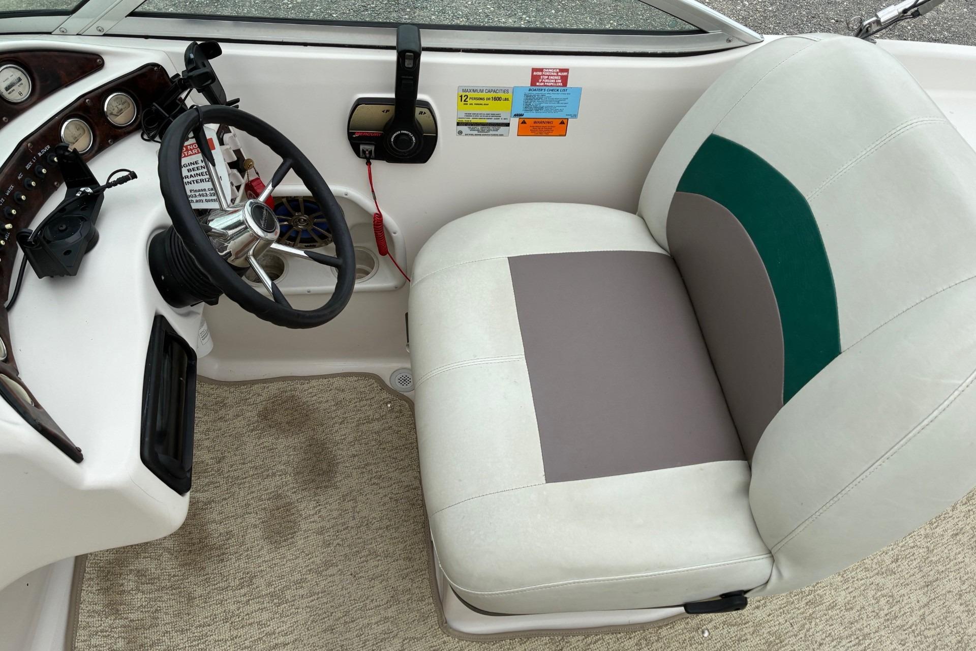 Interior of a 2003 Hurricane 234 SD boat with steering wheel and seat.