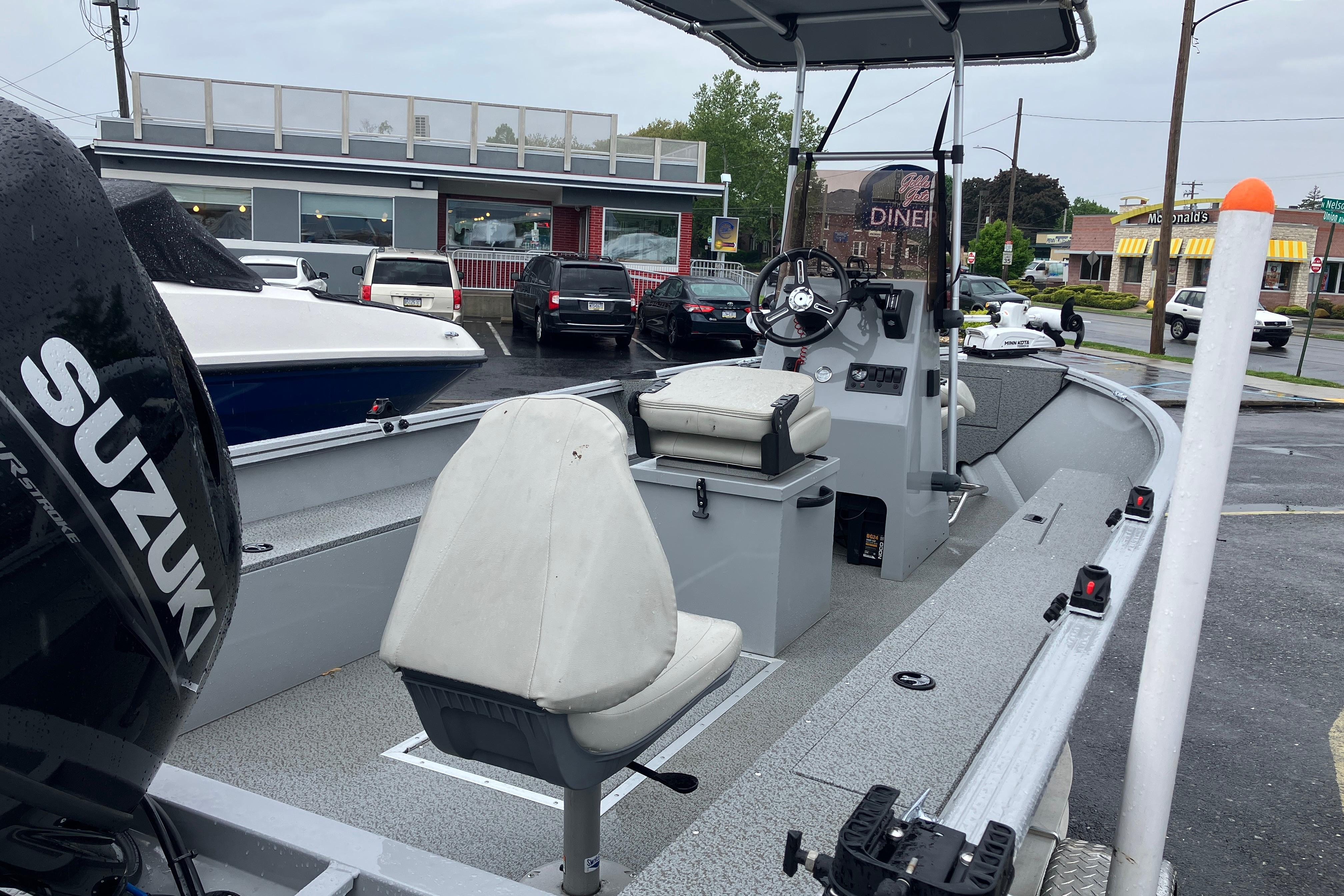 2024 Smoker Craft Freedom 180 CC boat with Suzuki engine, parked near a diner.