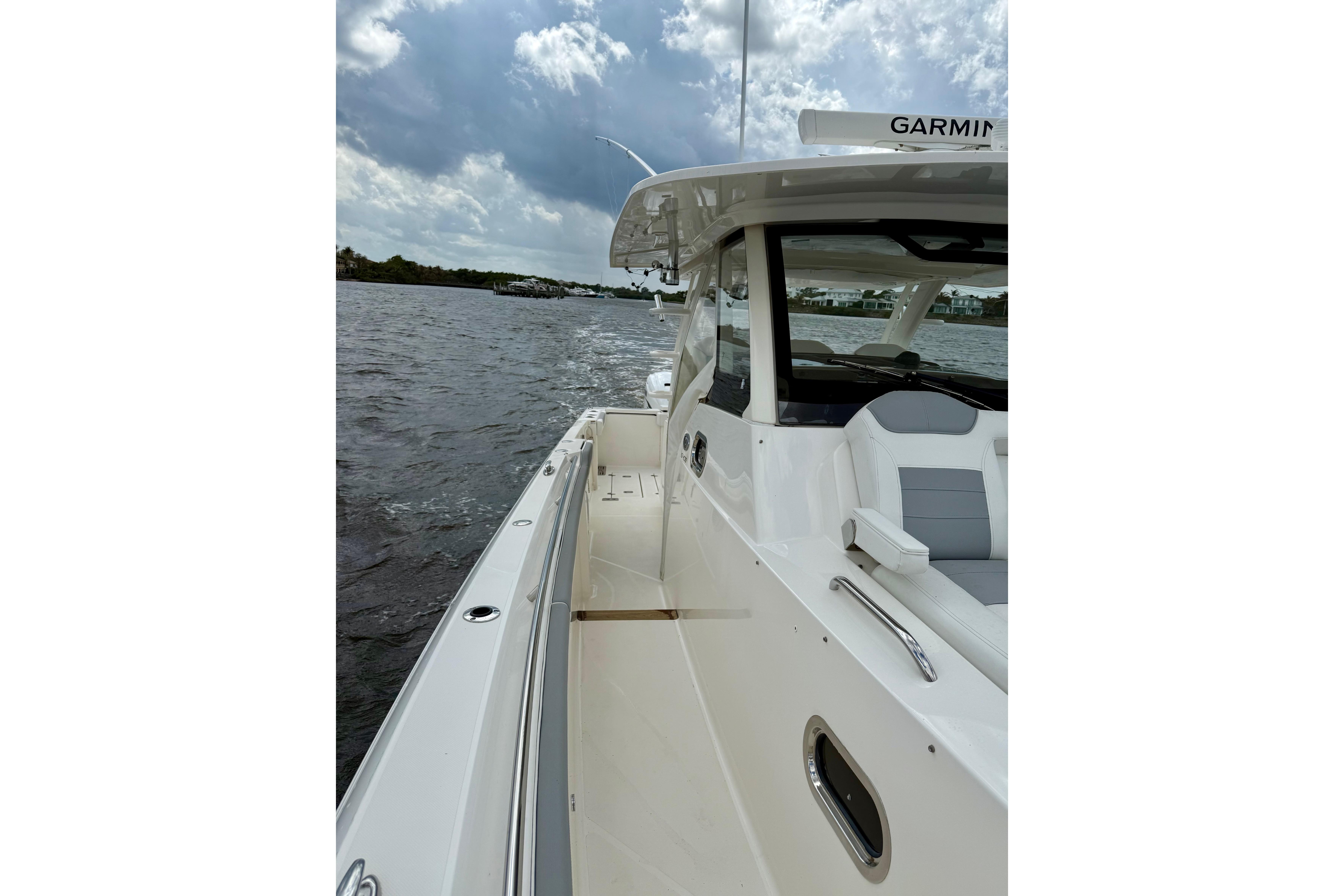 2020 Pursuit S 408 Sport boat on water under cloudy sky.