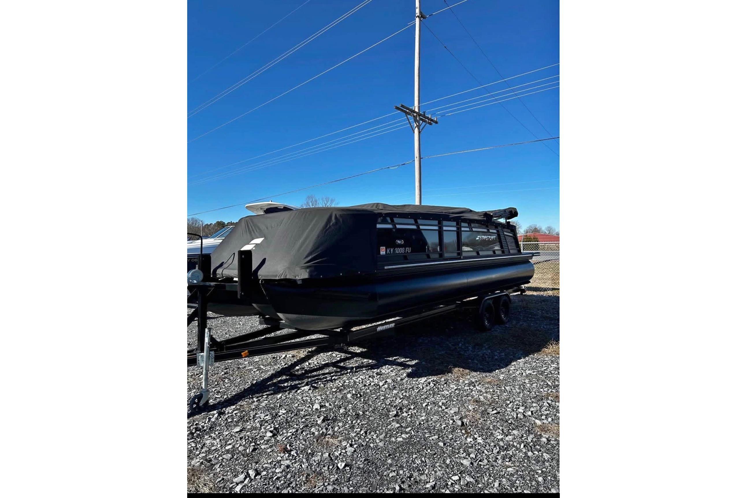 2023 Starcraft MX 25 DL DH pontoon boat covered on trailer, parked outdoors.
