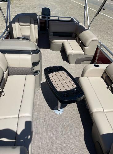 2025 Sun Tracker Party Barge 22 RF DLX interior with beige seating and central table.
