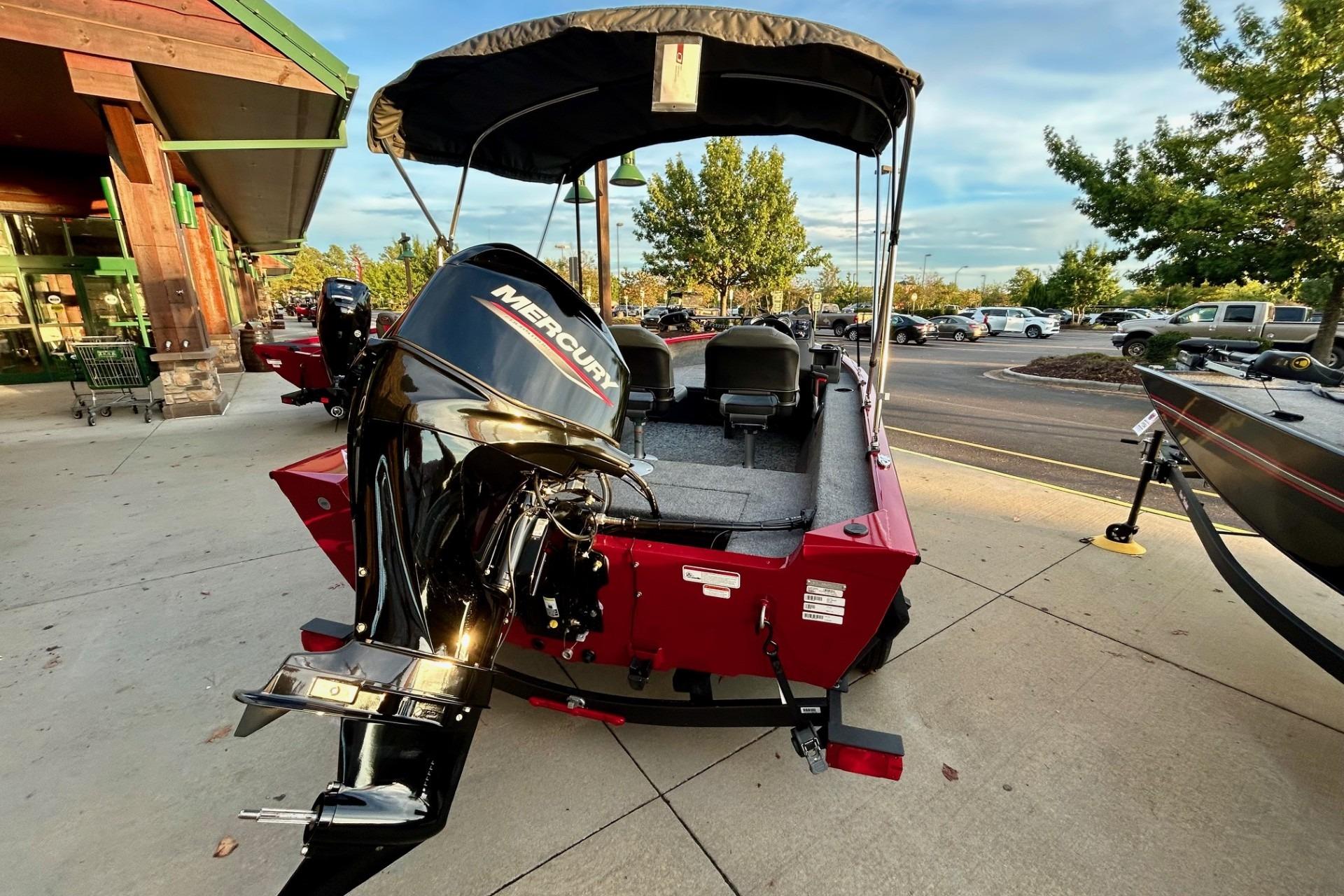 2026 Tracker Super Guide V-16 SC boat with Mercury engine, parked outdoors.