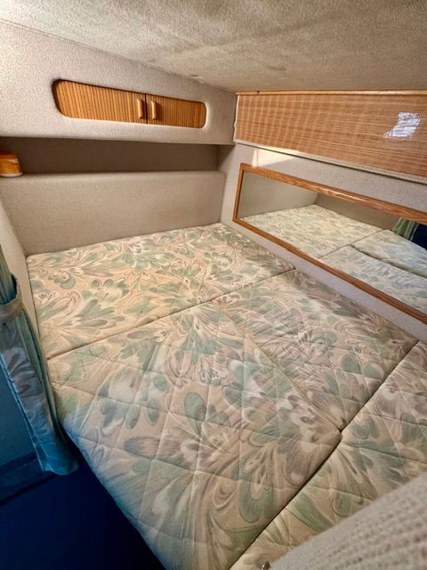 Interior of the 1992 Sea Ray 290 Sundancer featuring a cozy bed and mirror.
