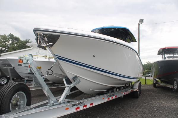 2024 Fountain 34 SC boat on trailer, sleek white design with blue accents.