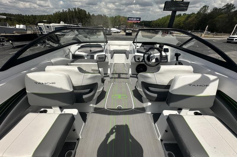 2024 Tahoe 210 S boat interior with modern seating and steering, parked outdoors.