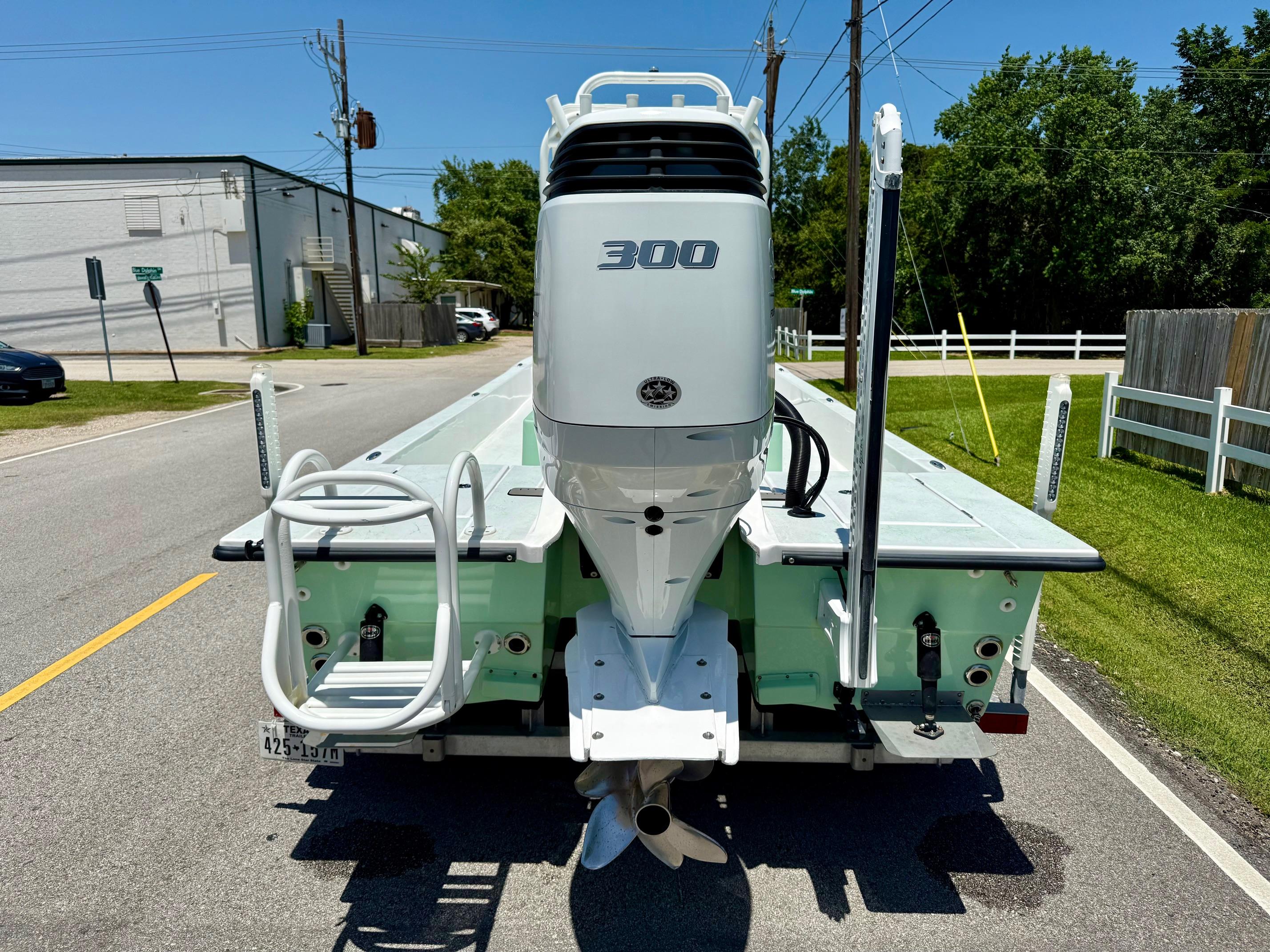2023 Shallow Sport 24 Sport boat with powerful 300 HP engine on a sunny street.