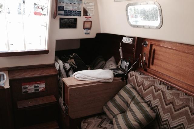 Interior of a 1980 Sloop 27.7 Bristol sailboat with cozy seating and nautical decor.