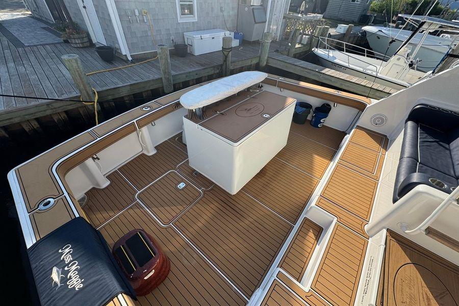 2002 Viking 61 Enclosed Bridge yacht deck with teak flooring and seating area.