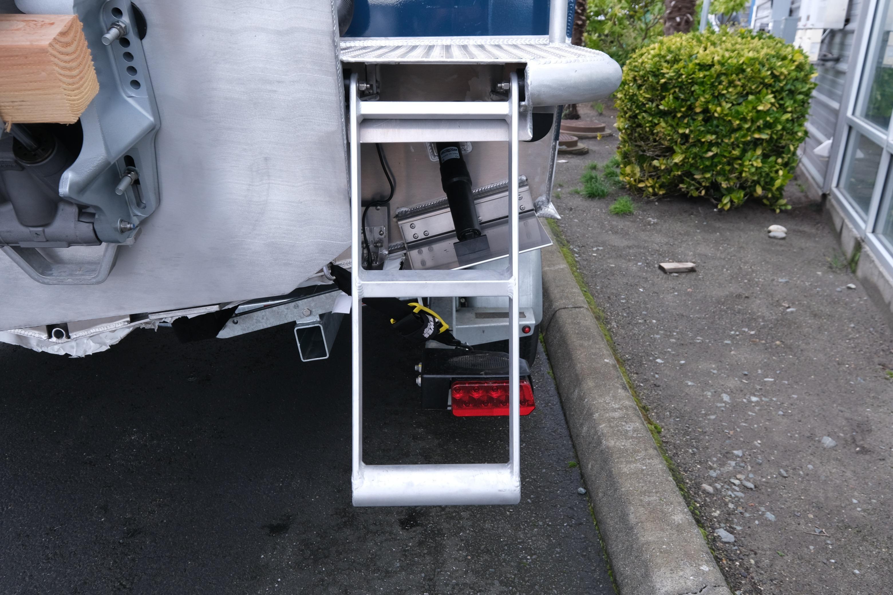 Rear view of 2026 Hewescraft 270 Pacific Explorer with ladder and trailer details.