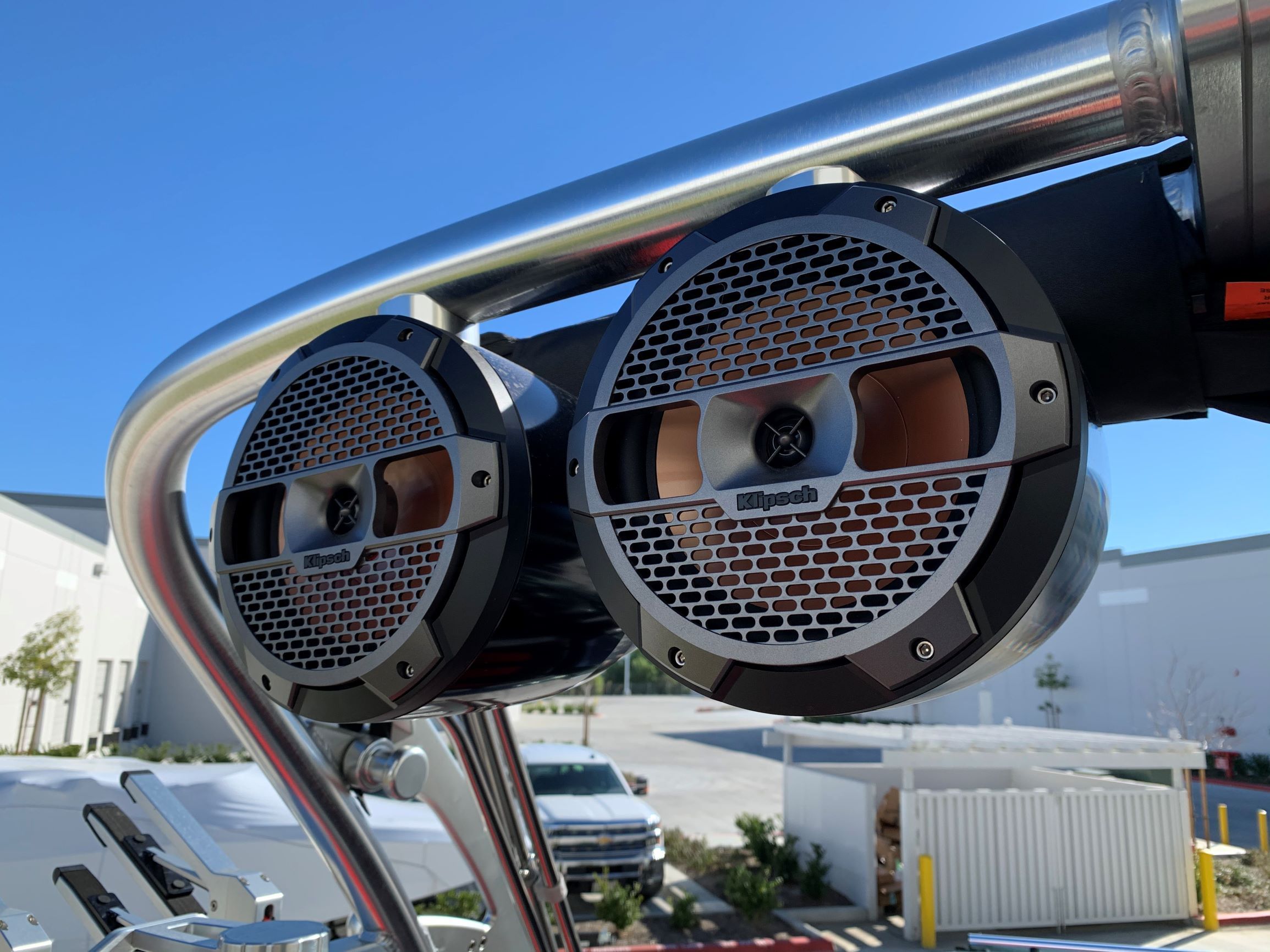 Two speakers are mounted on a metal frame on a boat.