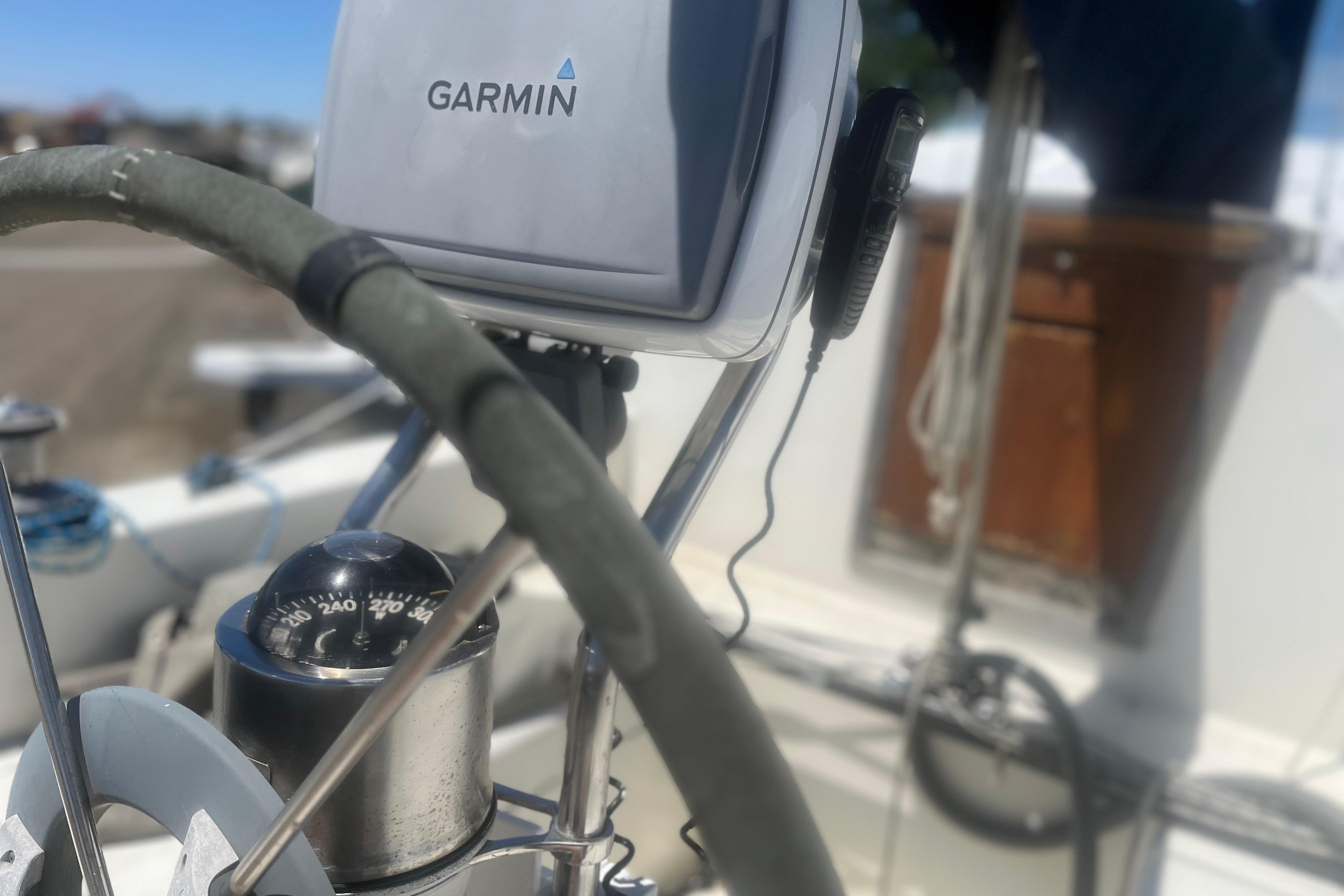 Steering wheel and compass on a 1972 C&C 30 sailboat with Garmin navigation.