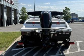 2024 Tahoe T18 boat parked outdoors, rear view with motor, near a building.