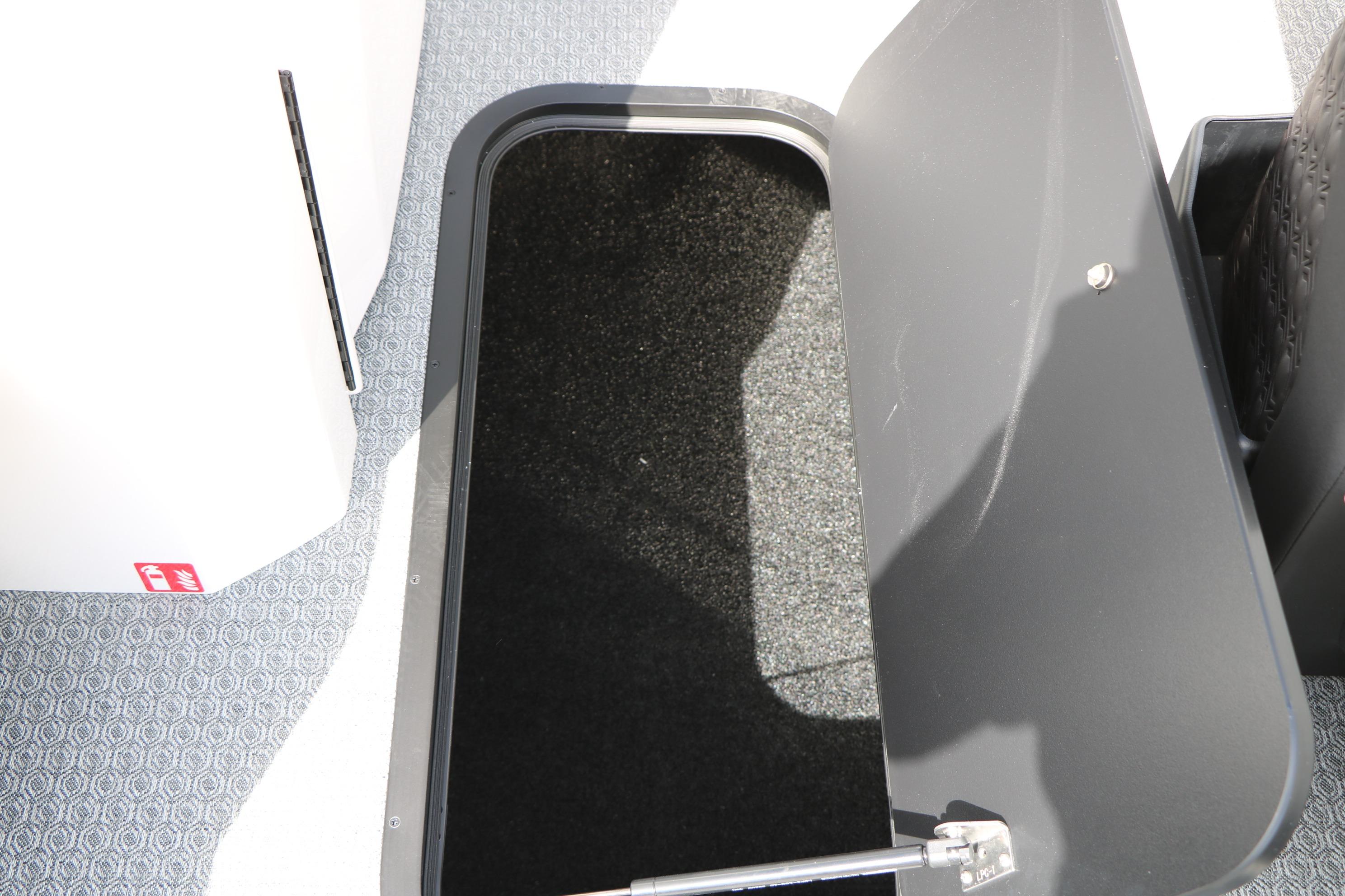 Open storage compartment on 2026 Evotti 725 CS Tri-Toon boat with carpeted interior.