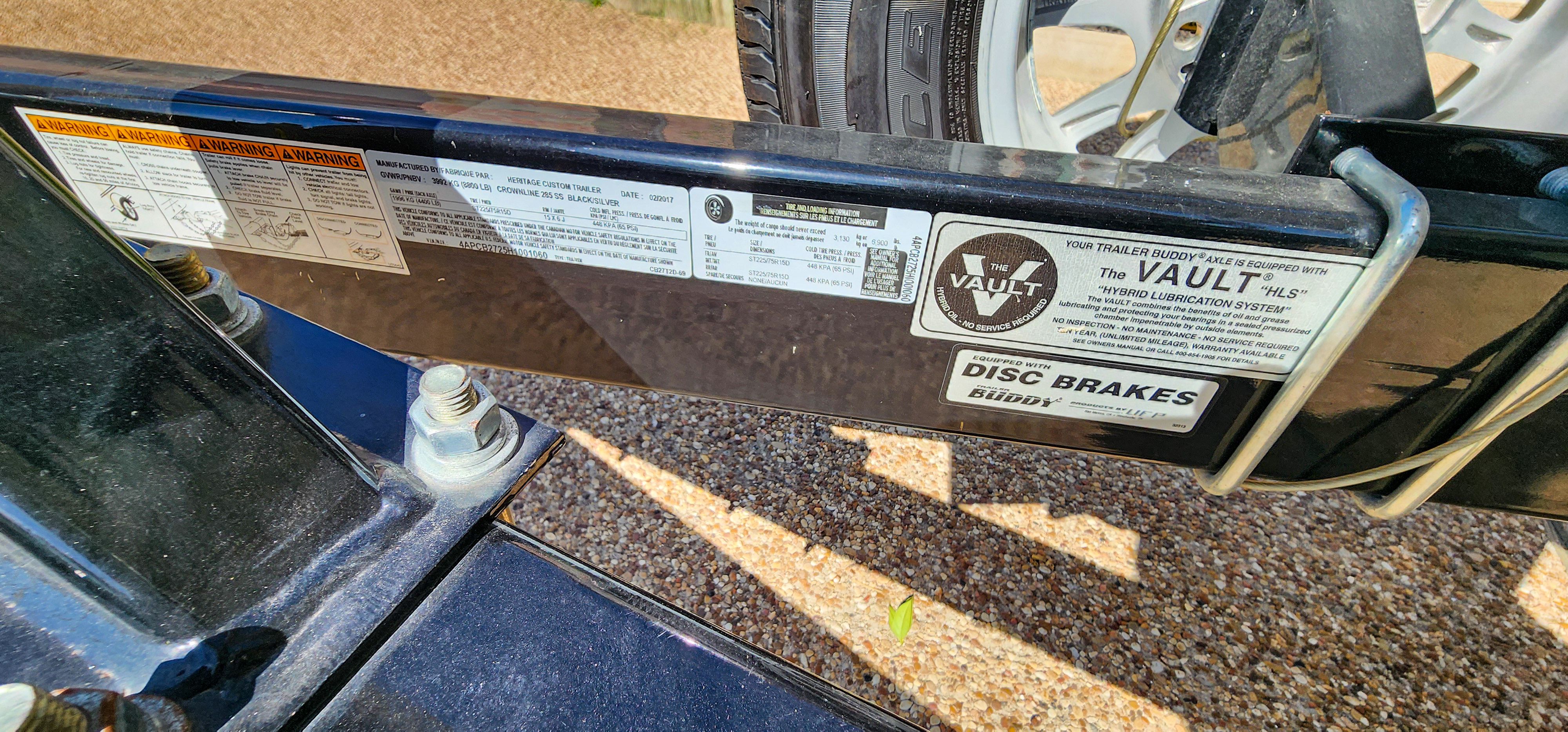 Close-up of a boat trailer with various warning and information stickers.