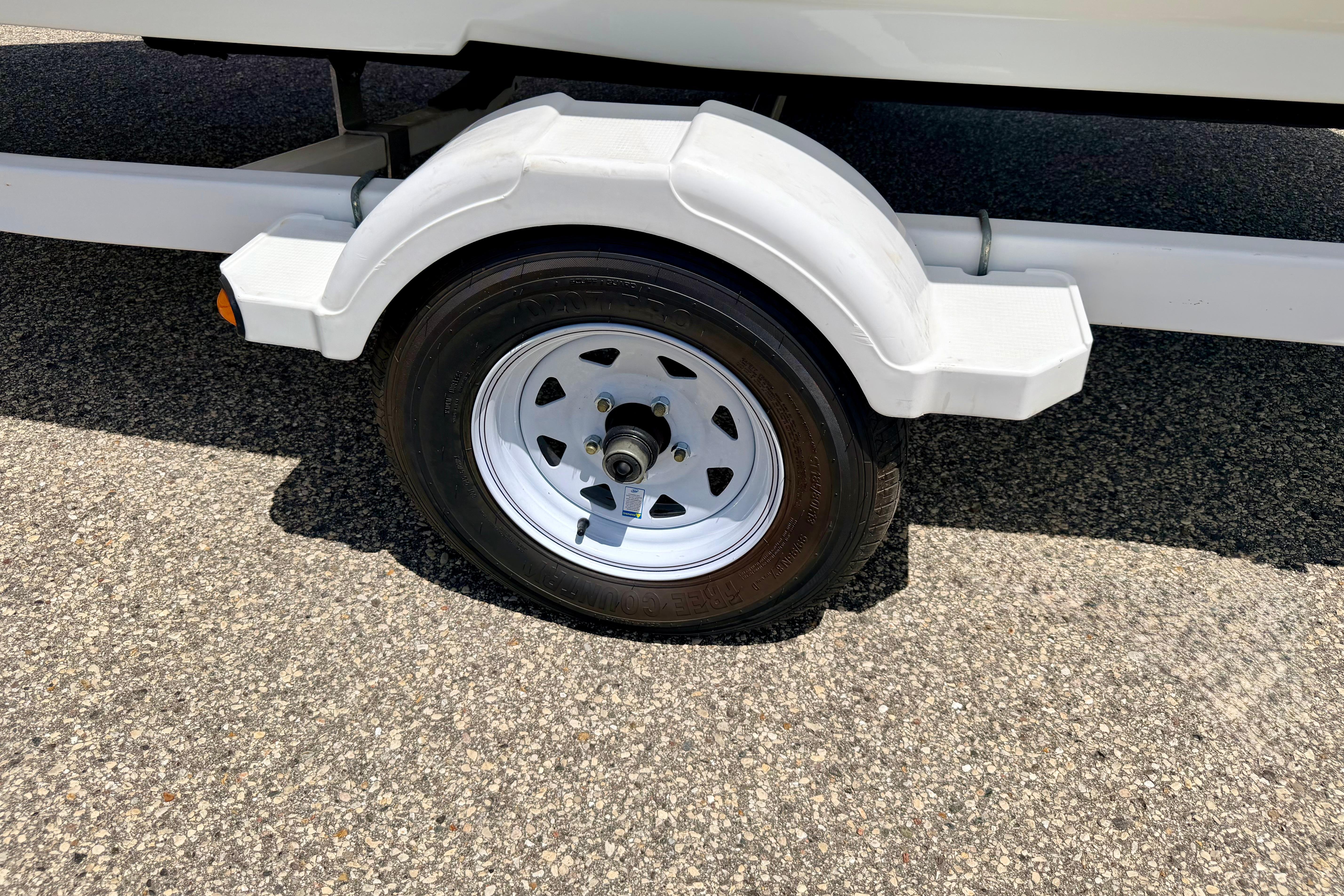 Trailer wheel of a 2004 Bombardier SEADOO Utopia 185 on asphalt surface.