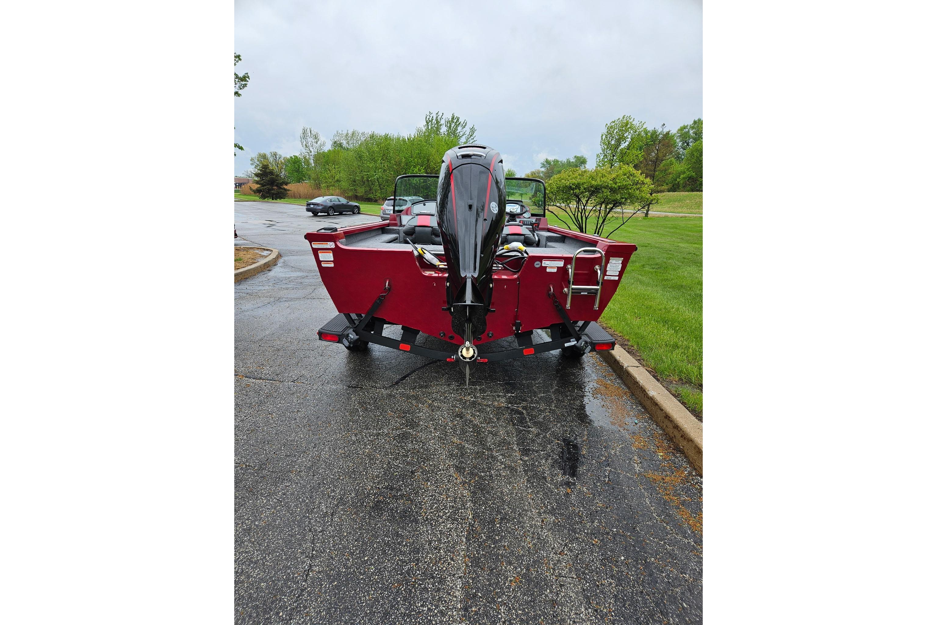 2026 Ranger VS1782SC Reata boat, red, parked on wet pavement, rear view.