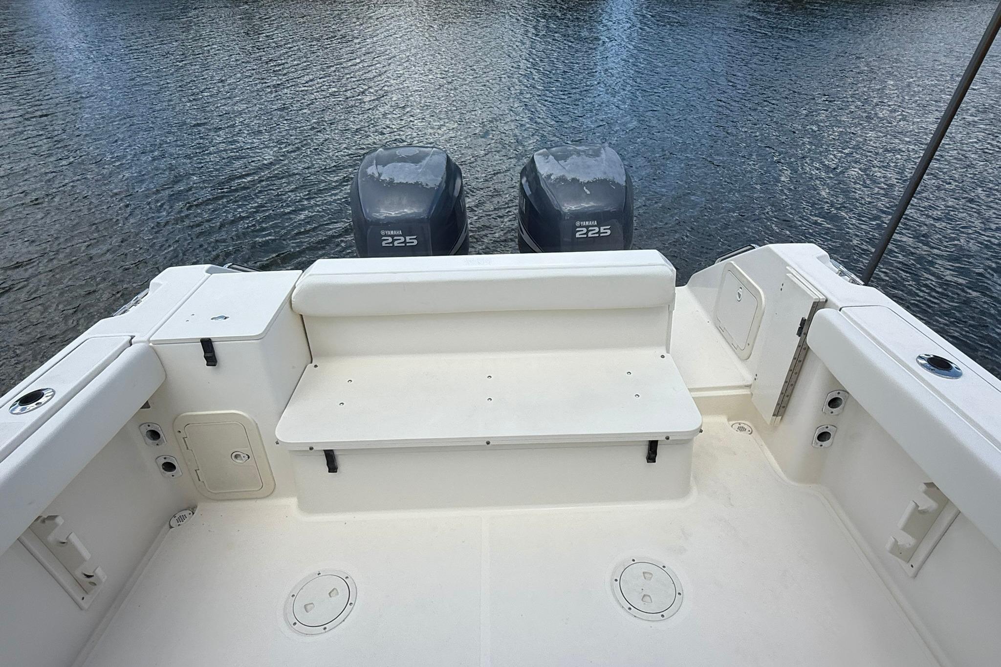 2003 Pursuit 2870 Walkaround boat with twin Yamaha 225 engines on calm water.