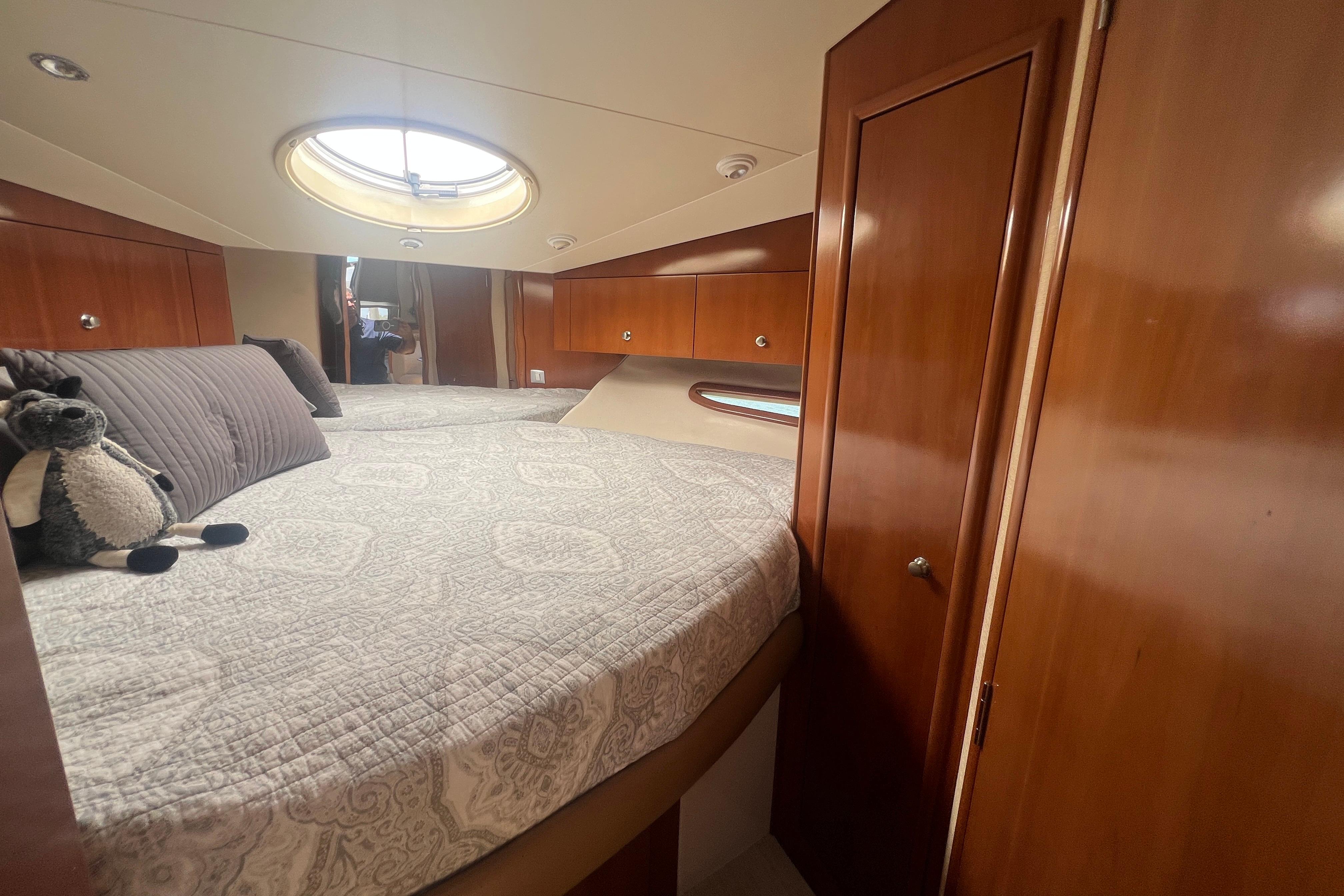 Luxurious bedroom interior of 2006 Carver 43 Motor Yacht with plush bedding and wood paneling.