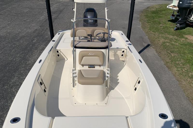 2025 Scout 177 Sport boat with beige seating and center console, parked on pavement.