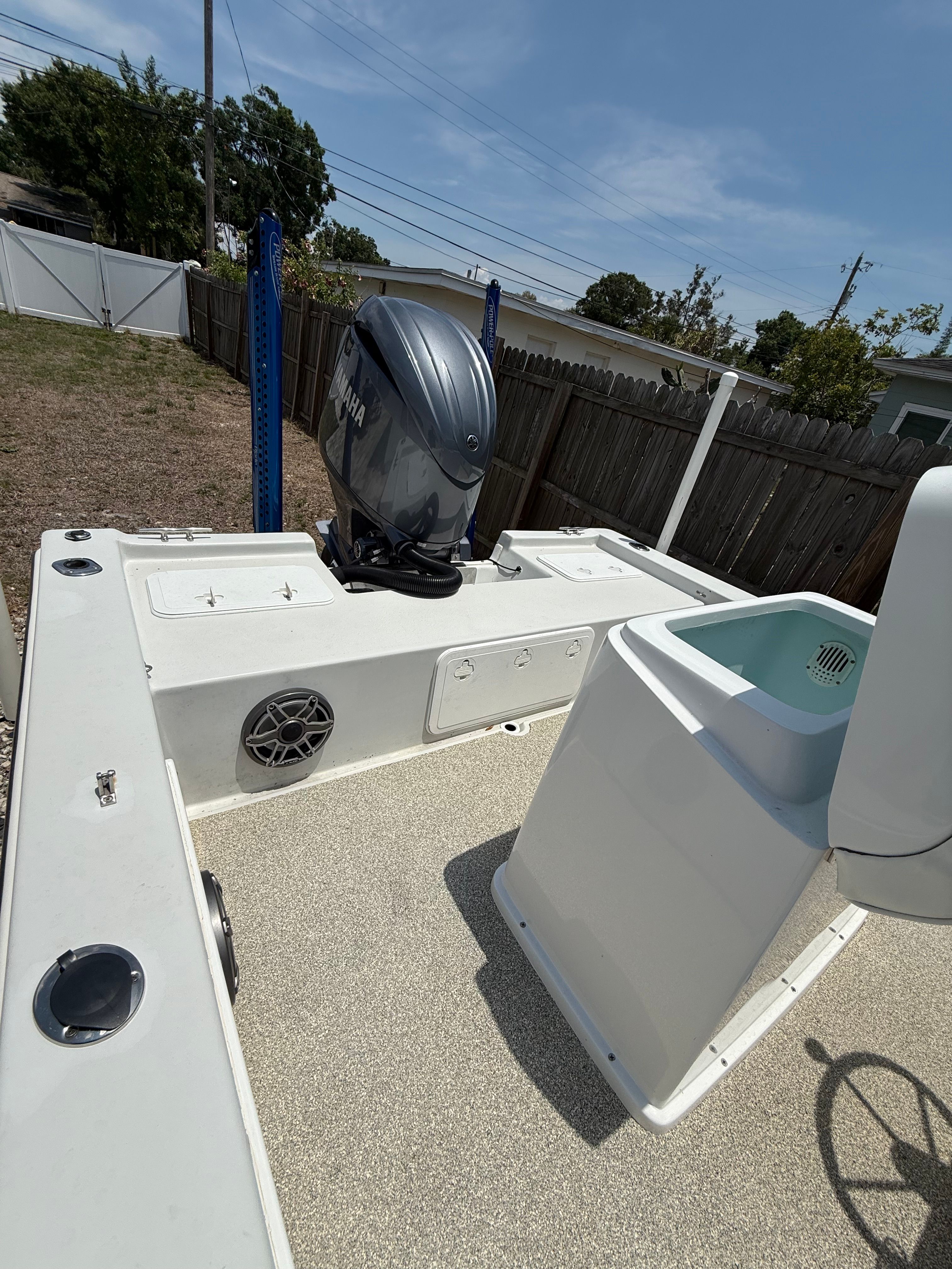 2012 Bay Craft 21 boat with outboard motor in backyard.