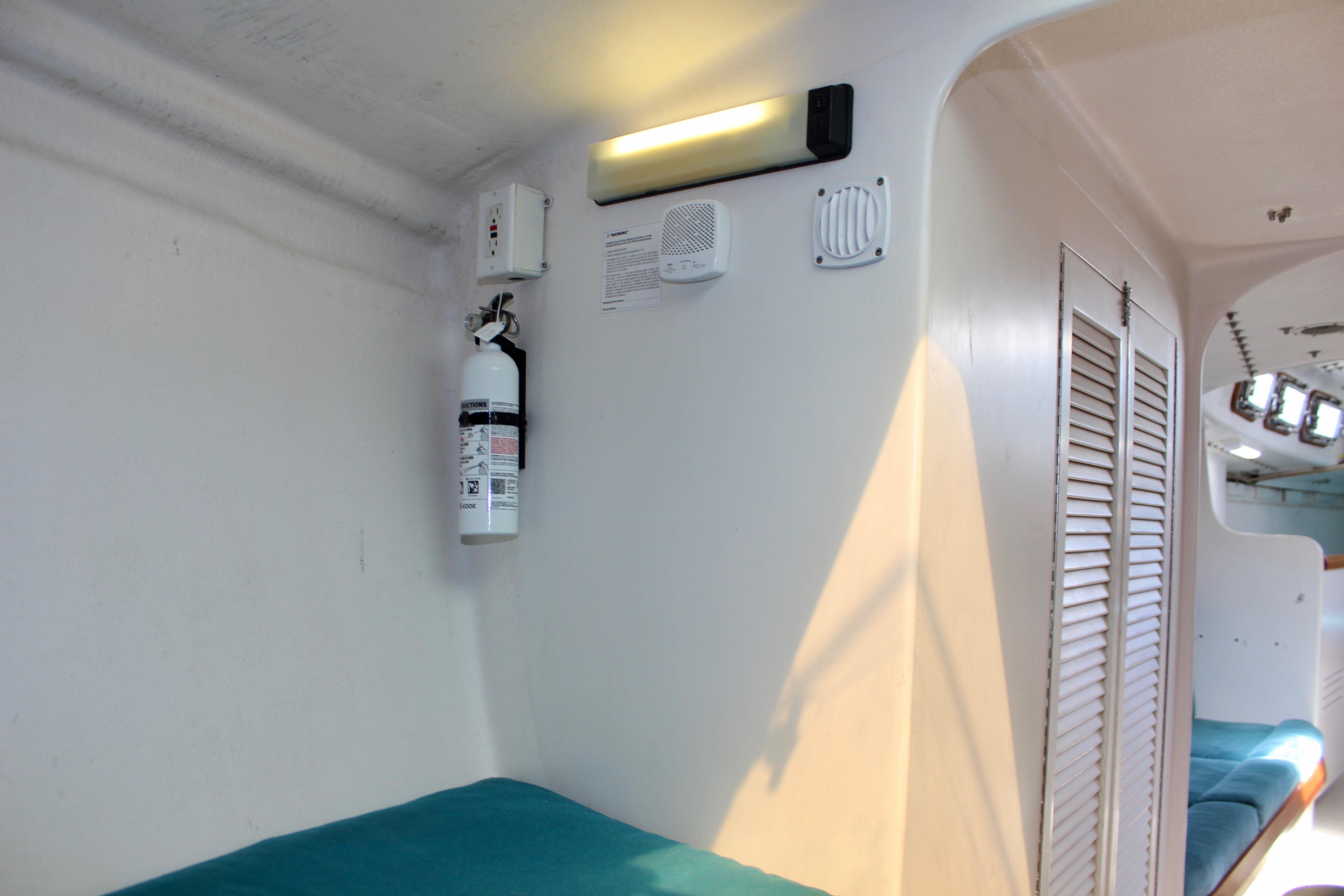 Interior of 1993 Freya 39 yacht with fire extinguisher and teal seating.