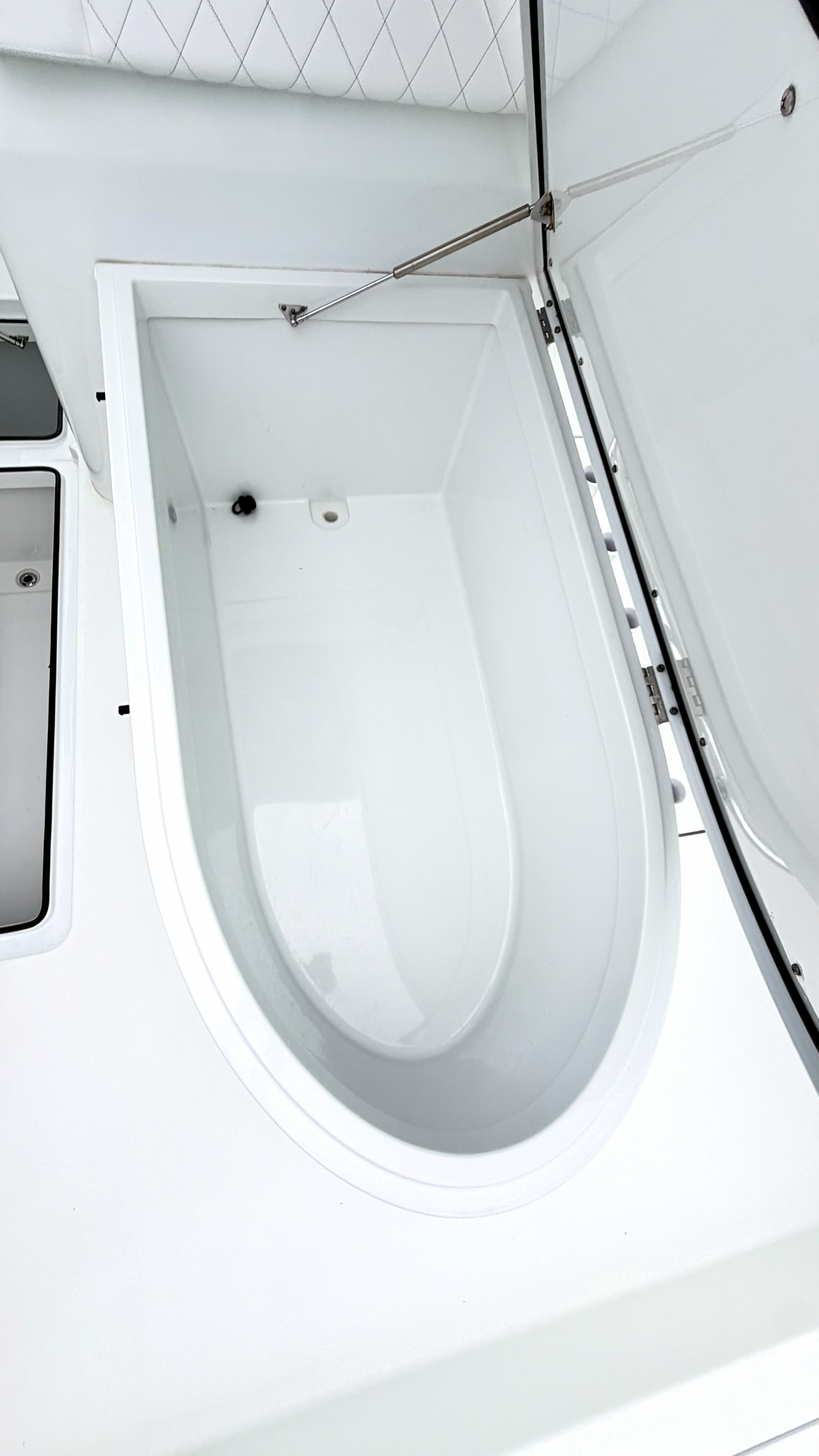 An open, oval storage compartment on a boat.