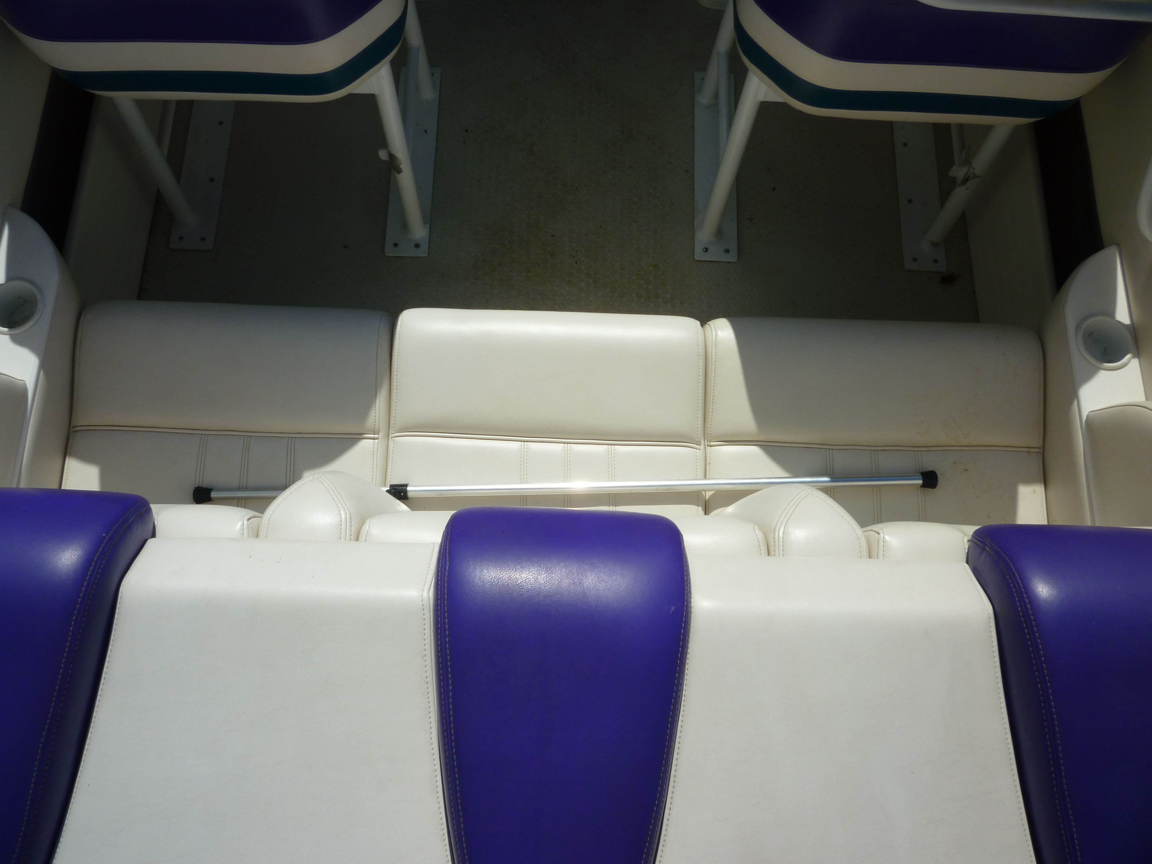 Interior of a 2000 Velocity 280 boat with white and purple seating.