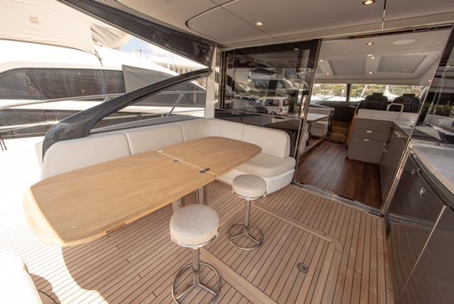 Luxurious 2024 Princess V55 yacht interior with elegant seating and wooden flooring.