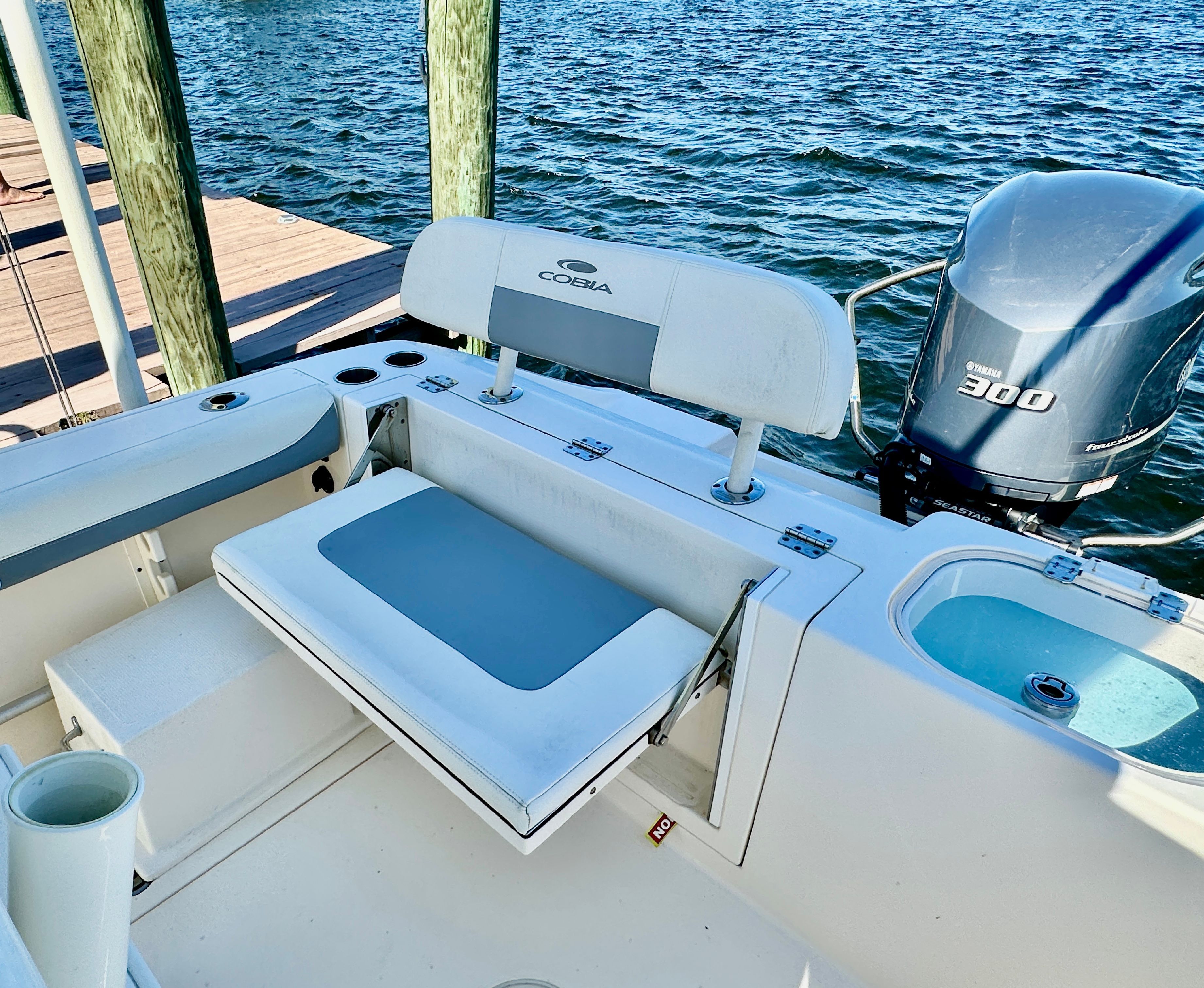 A 2022 Cobia 240 Center Console with seating and Yamaha engine, docked by the water.