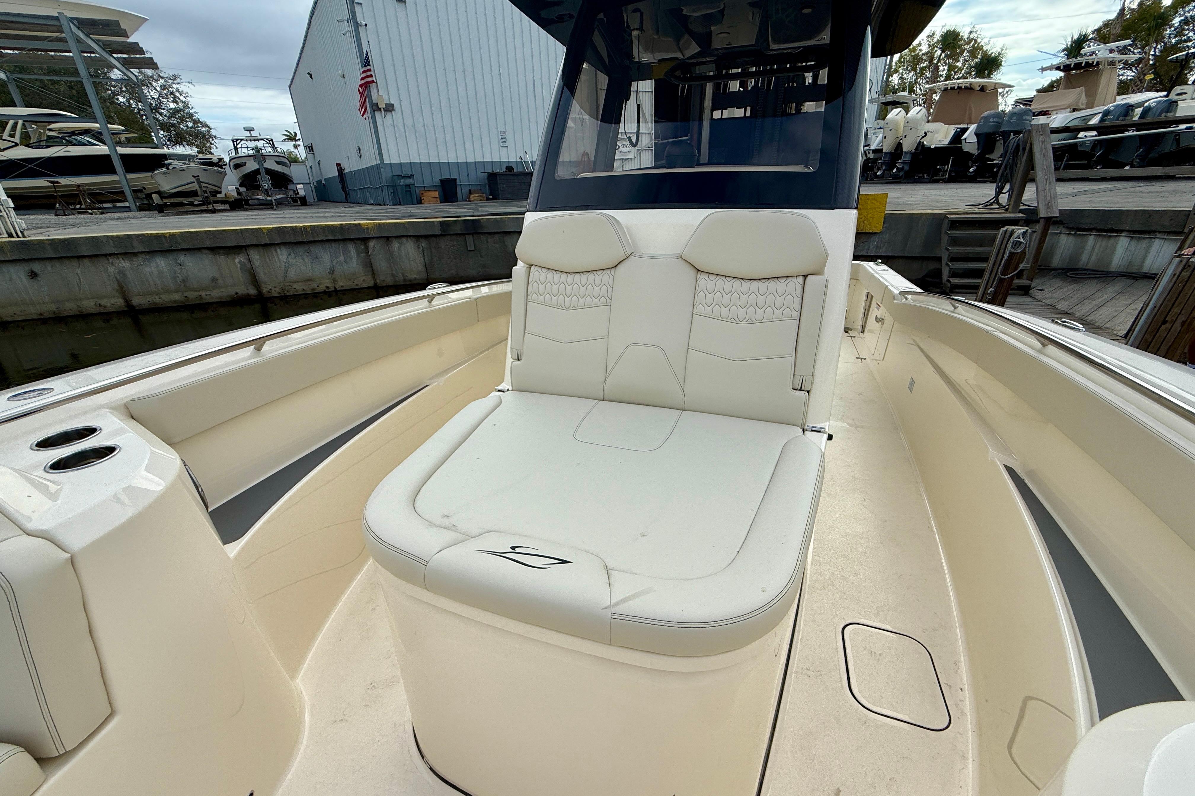 2026 Scout 288 LXF boat interior with cushioned seating and cup holders at a marina.