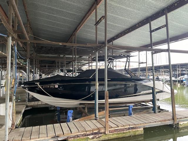 2017 Scarab 255 boat docked in a marina under a covered structure.