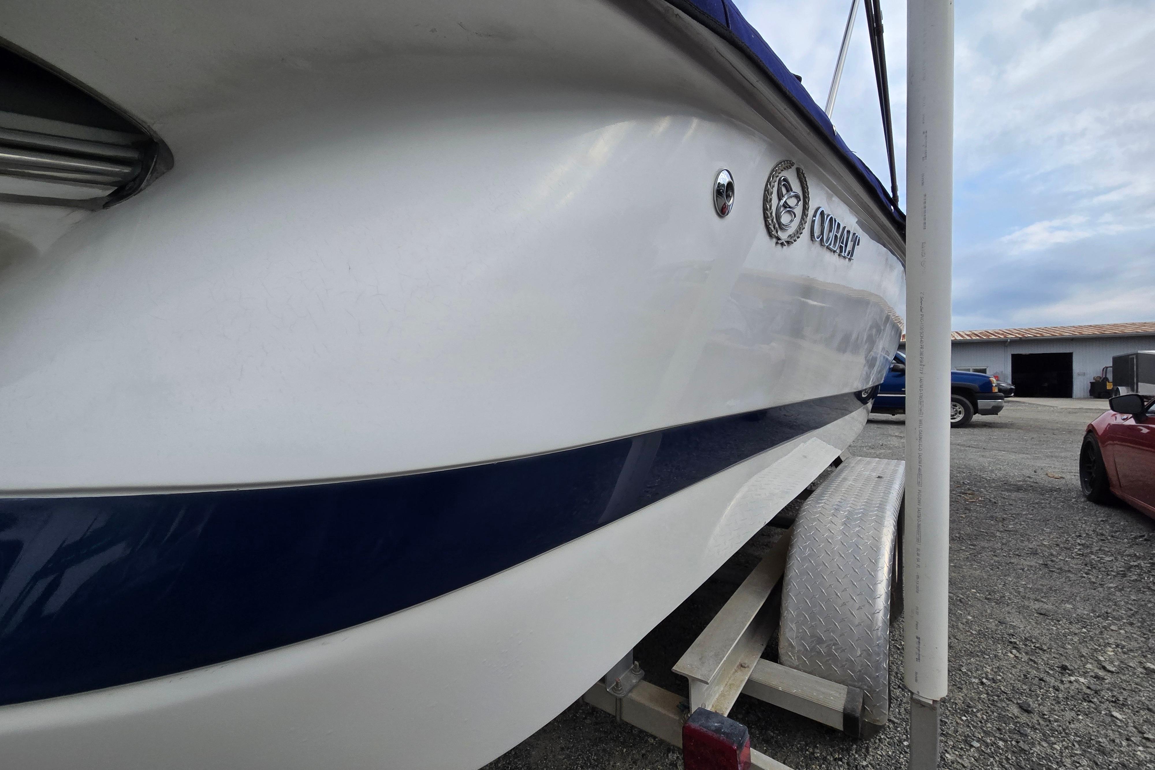 2000 Cobalt 246 boat on trailer, side view with logo, parked outdoors.