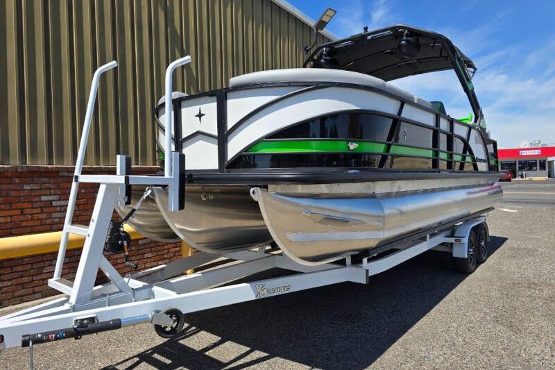 2026 Berkshire STS Arch Performance Series pontoon boat on trailer, parked outdoors.