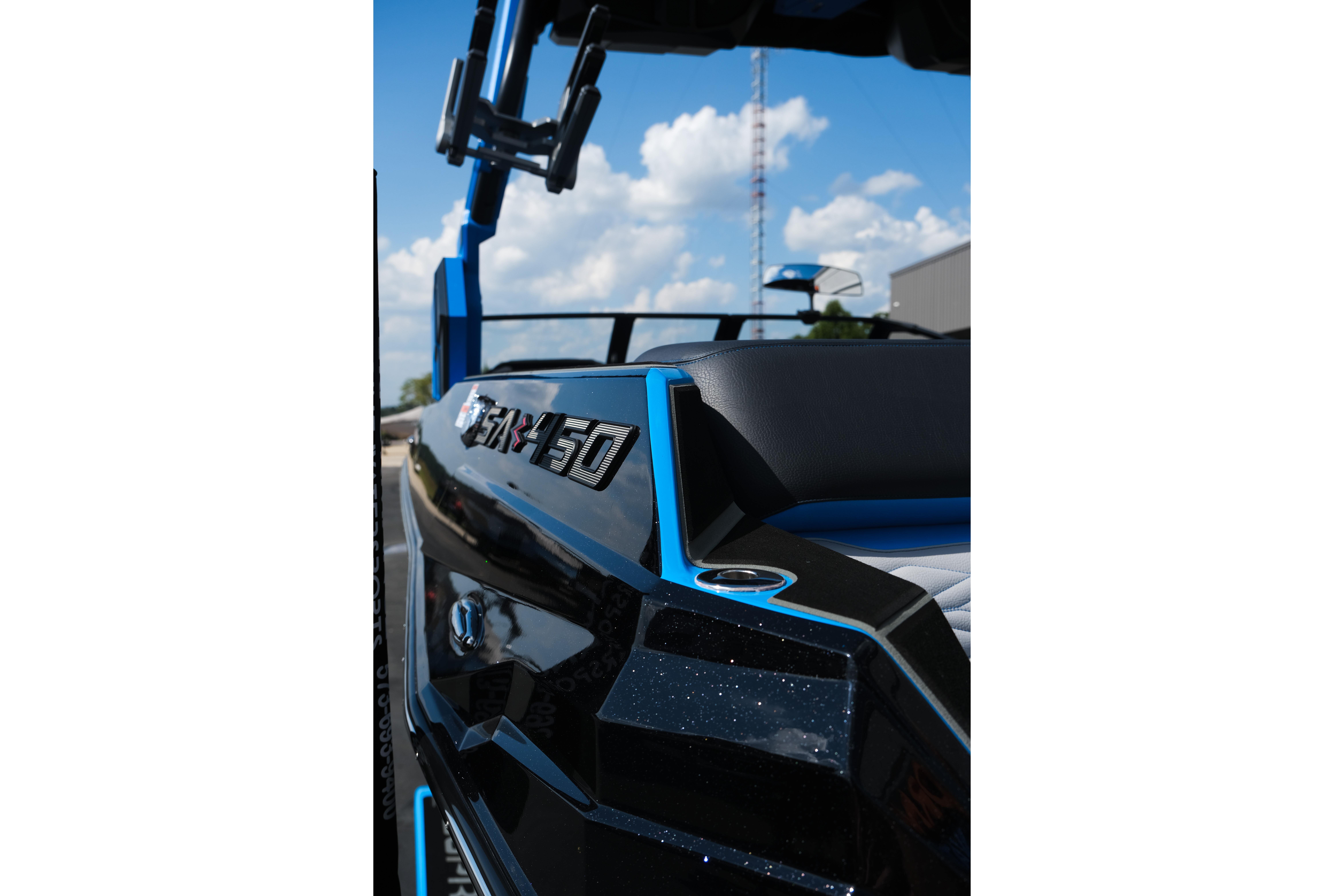 2026 Supra SA450 boat, sleek design, blue and black accents, under a clear sky.